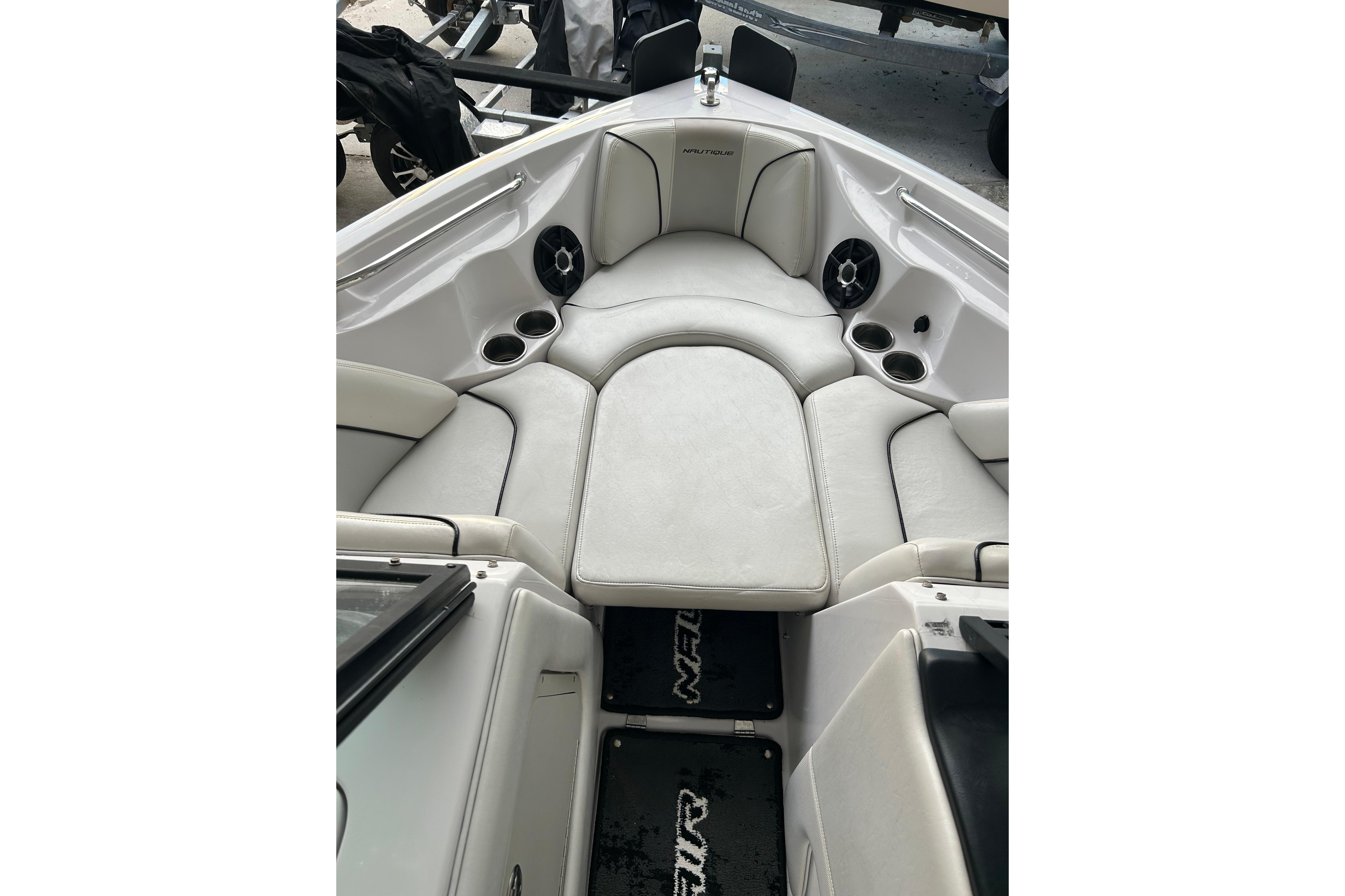 2010 Nautique Super Air Nautique 210 Coastal Edition interior with cushioned seating and cup holders.