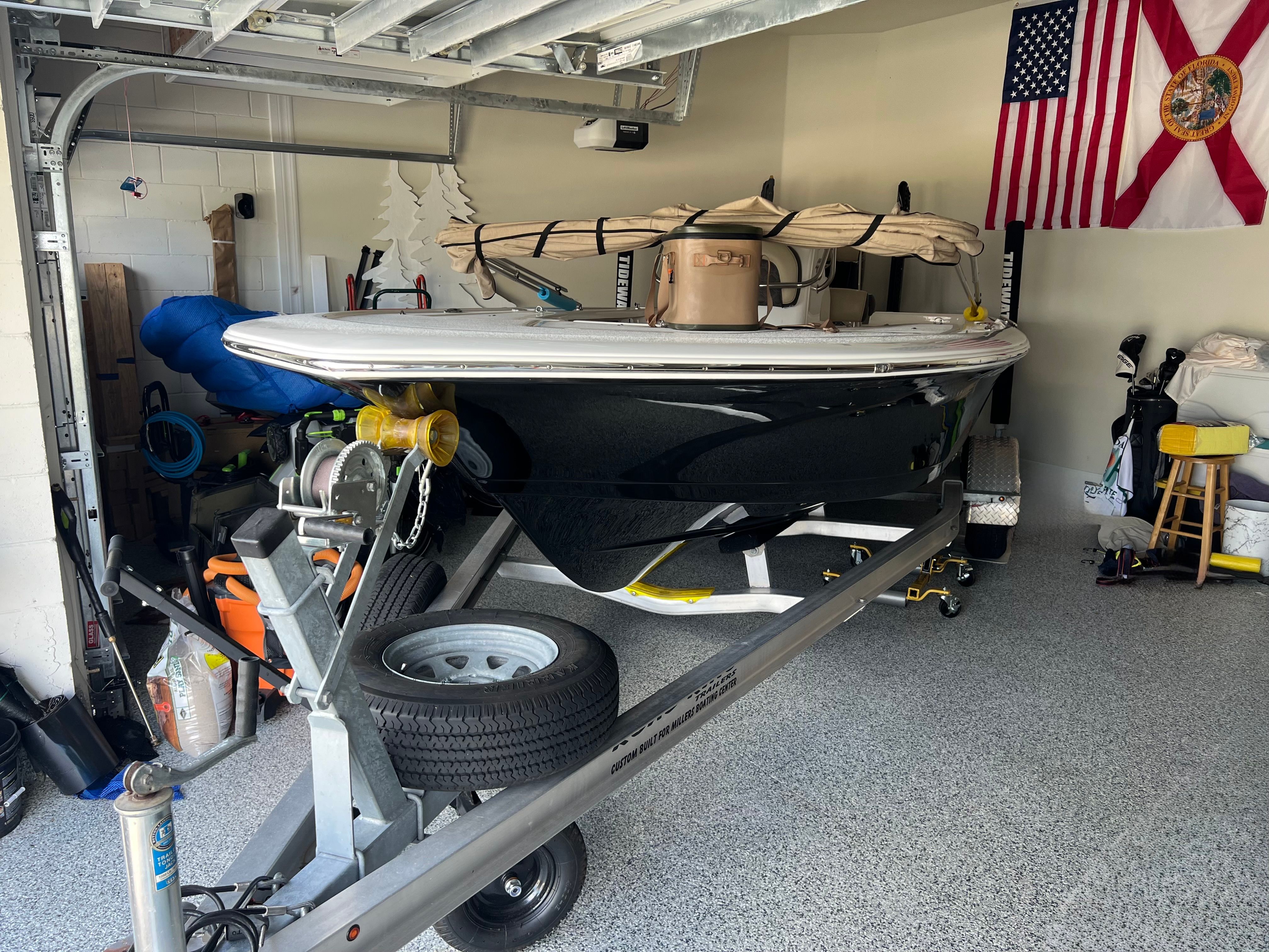 A 2021 Tidewater 1910 Bay Max boat on a trailer in a garage.