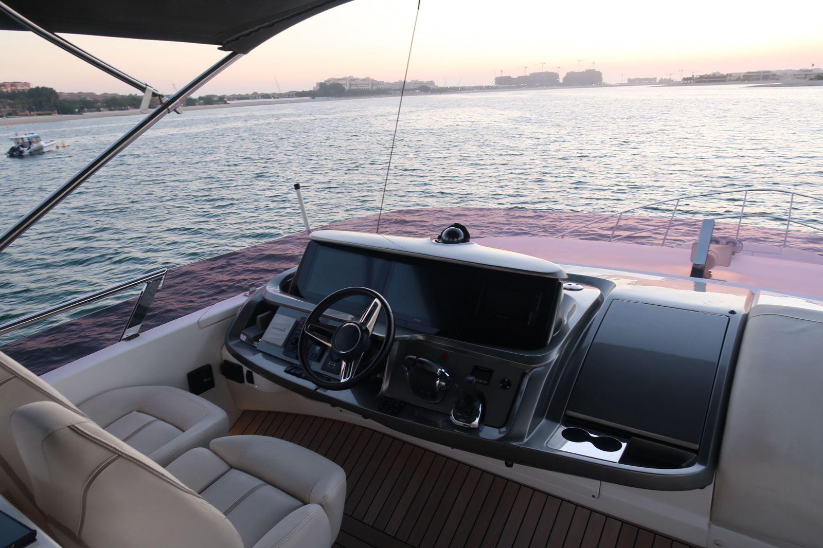 Luxury yacht Princess F55 helm overlooking serene waters at sunset, 2020 model.