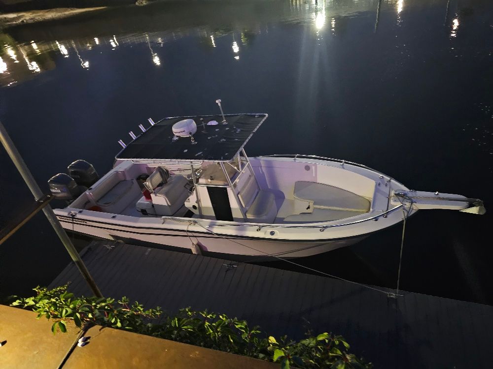 A 1997 Grady-White Chase 263 boat docked on calm water at night.
