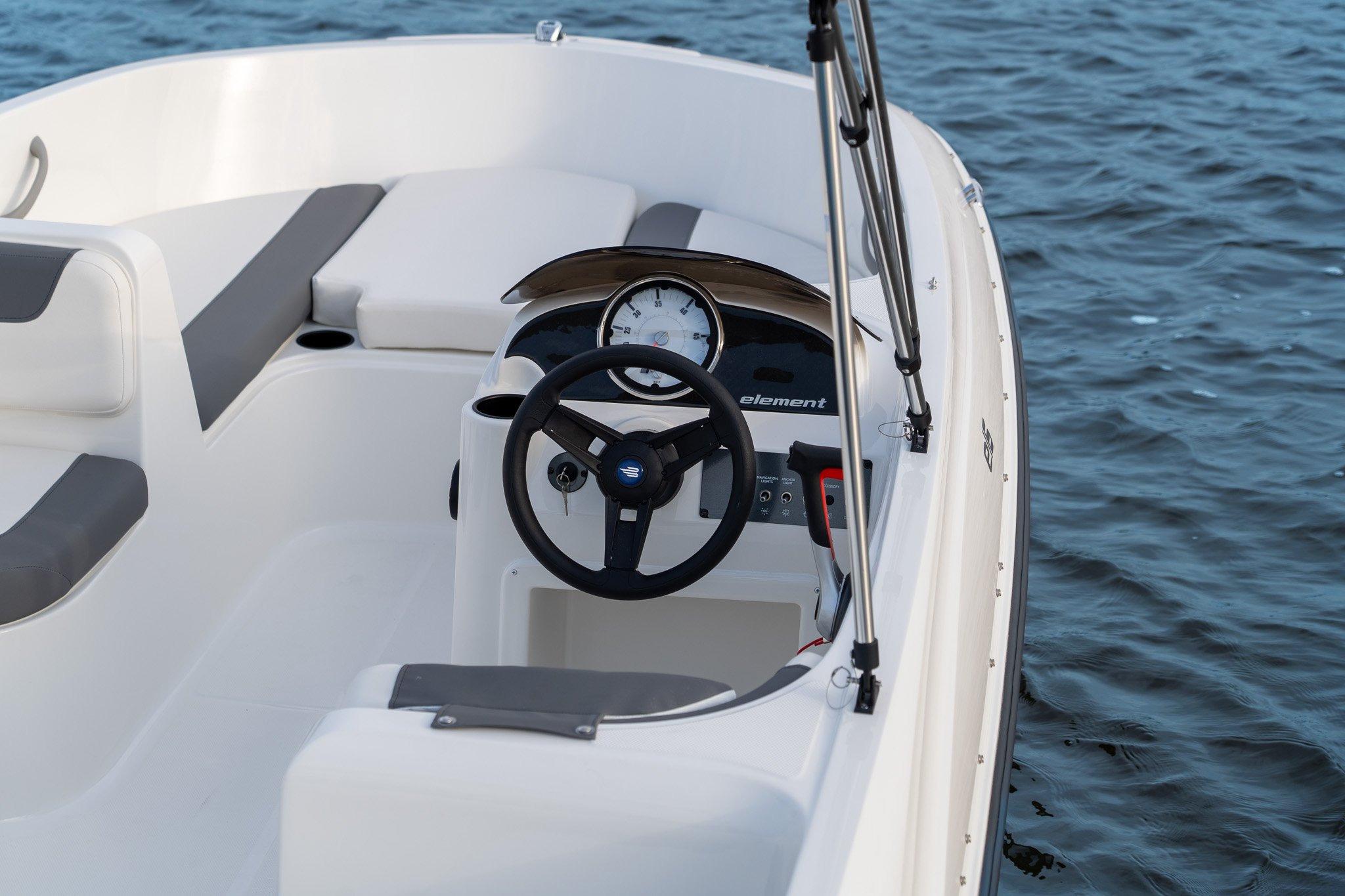 Manufacturer Provided Image: 2025 Bayliner Element E16 boat interior with steering wheel, dashboard, and seating on water.