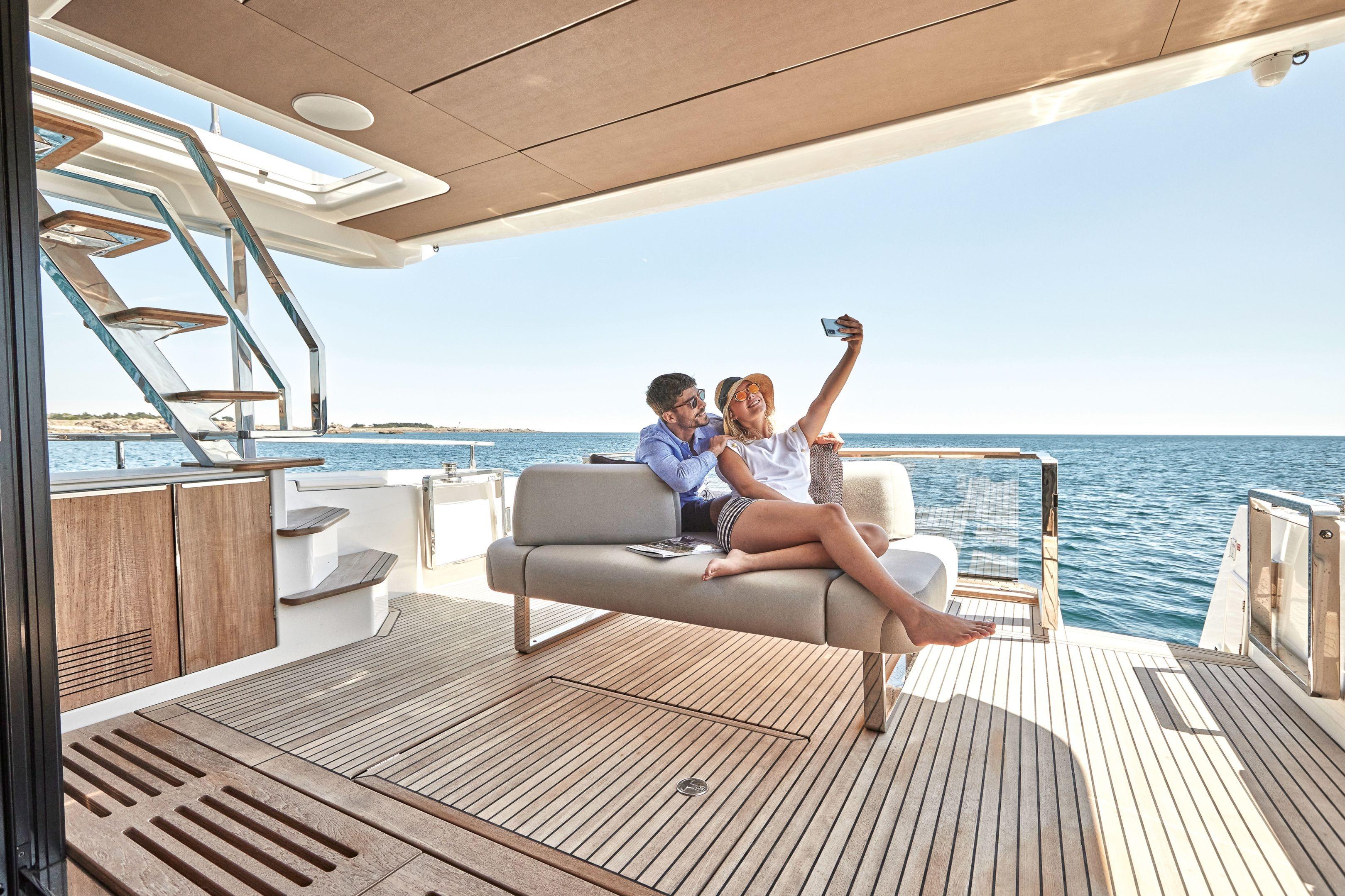 Couple taking a selfie on a 2026 Prestige X60 yacht deck, enjoying the ocean view.