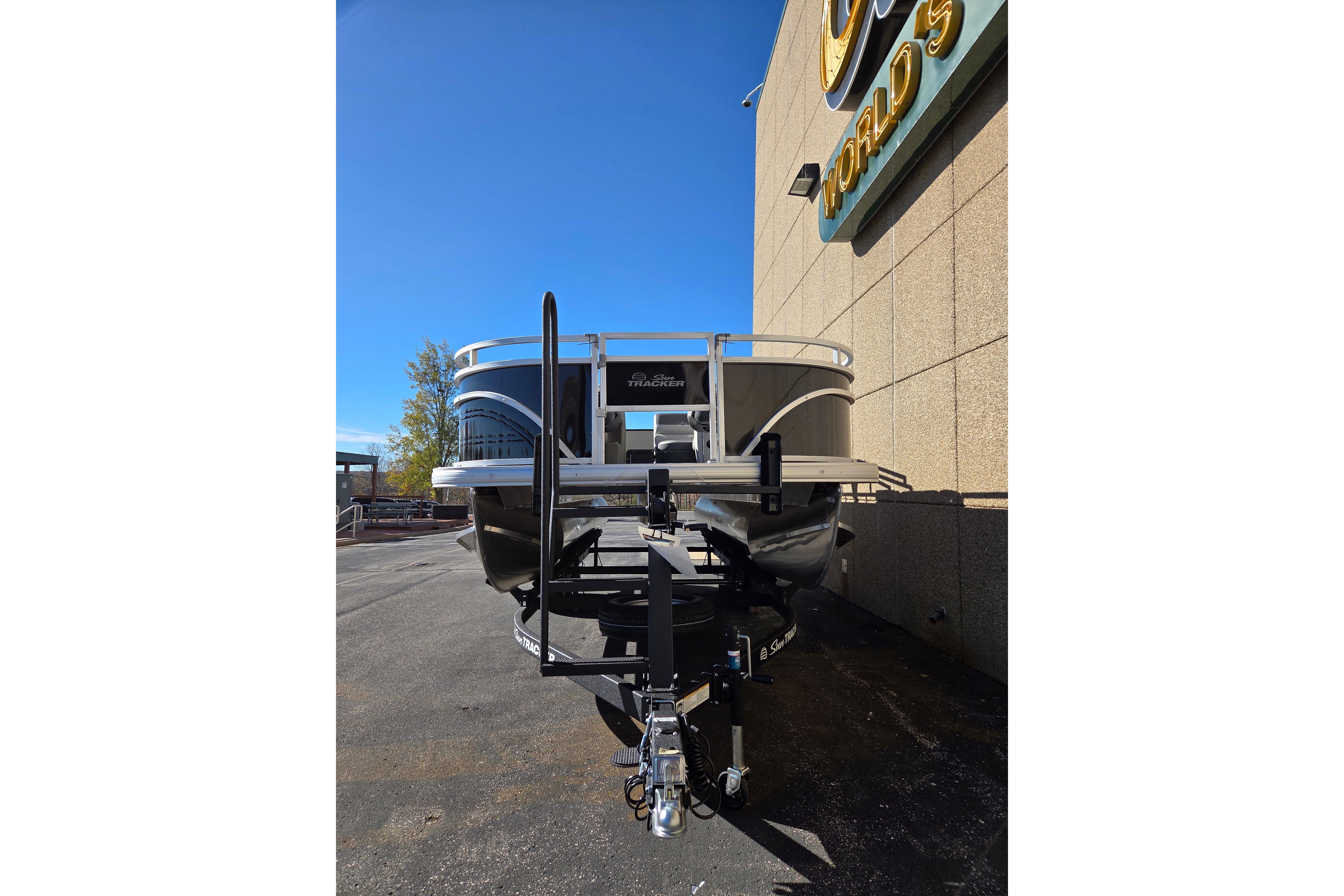 2026 Sun Tracker Fishin' Barge 20 DLX pontoon boat parked outdoors.