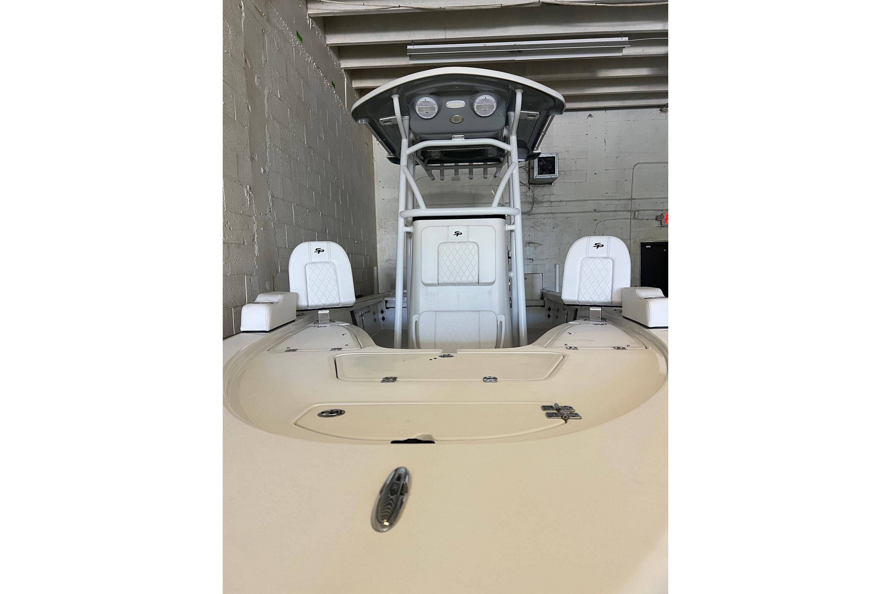 2024 Sea Pro 230 Bay boat in a garage, showcasing seating and helm.