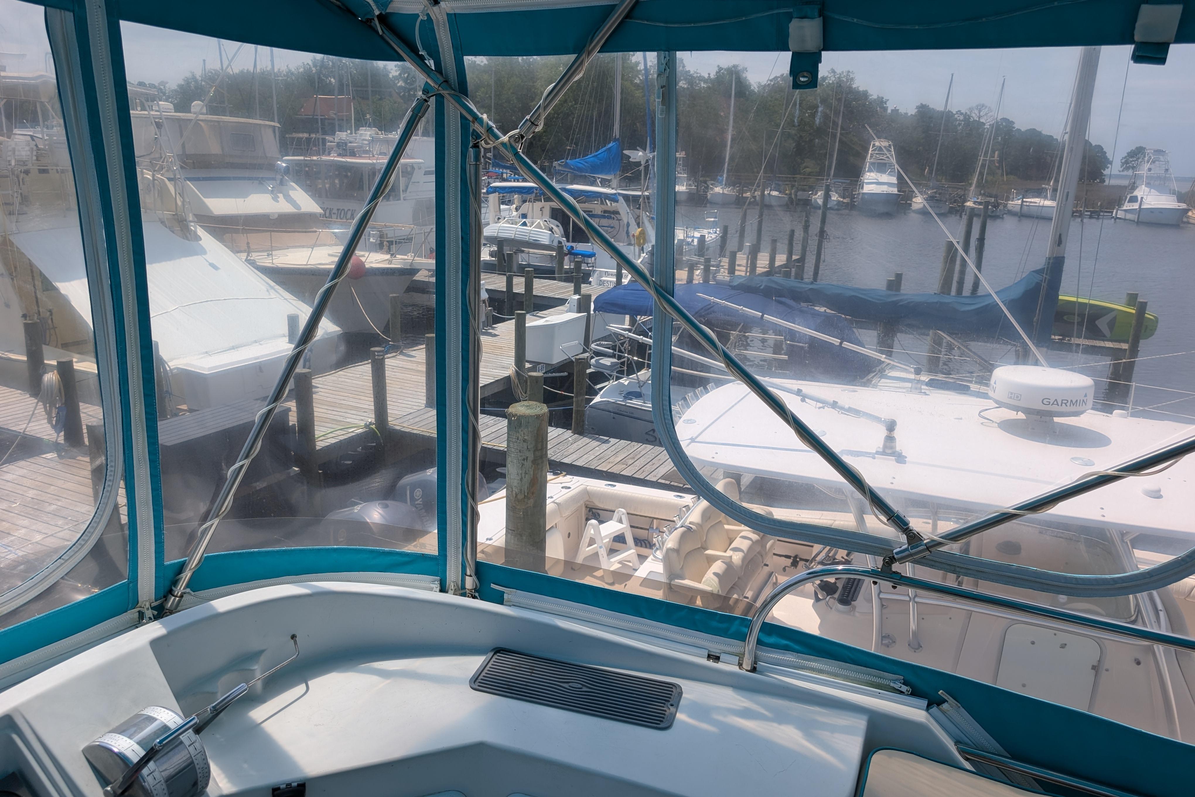2004 PDQ 34 Powercat at marina, view from cockpit with boats and docks visible.