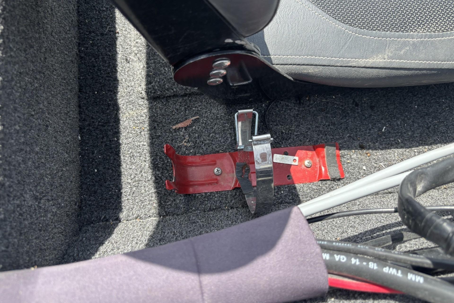 Red metal bracket on carpeted floor of 2019 Lowe Skorpion 17 boat interior.