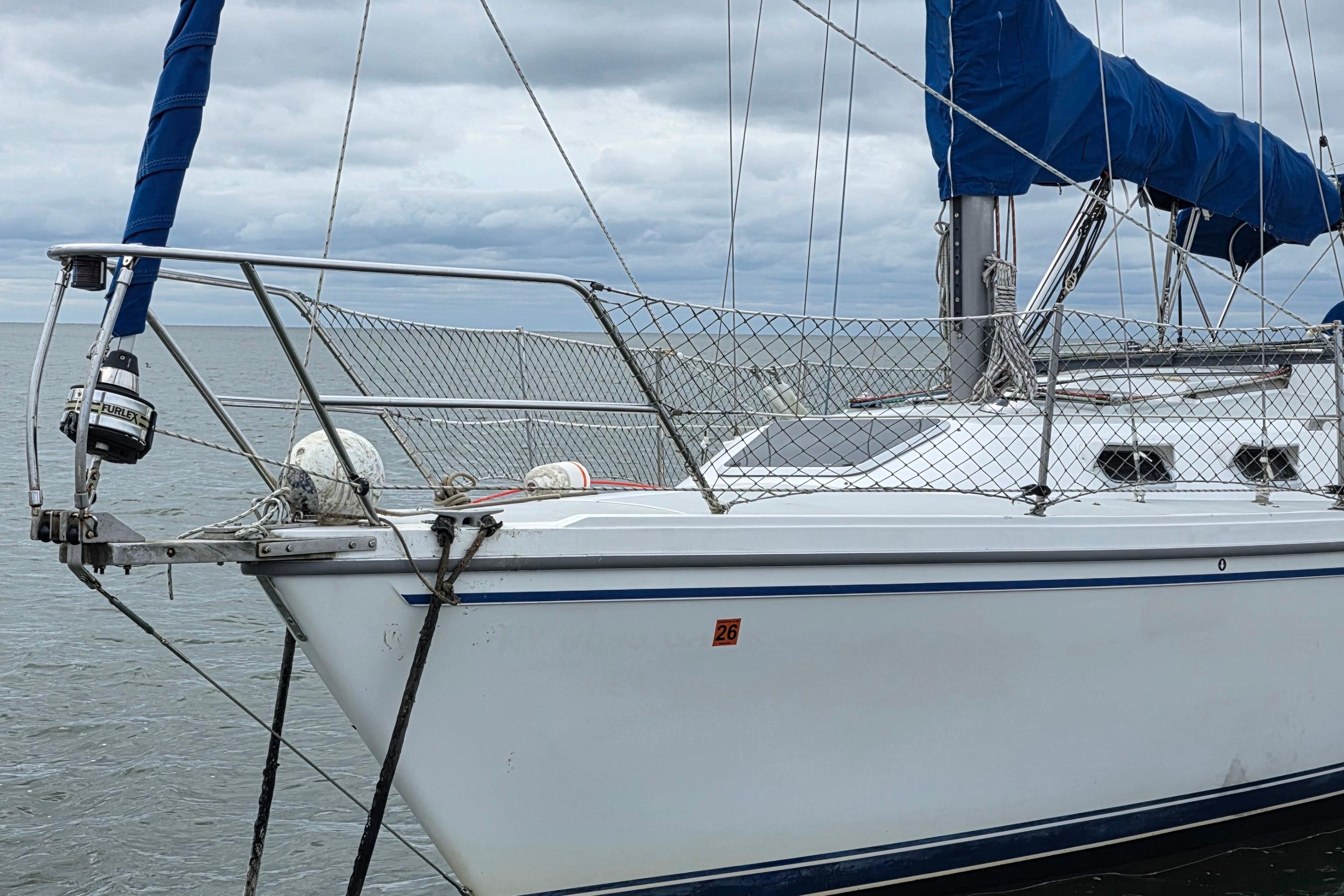 1987 Catalina 30 MkII sailboat with blue sail cover on calm water.