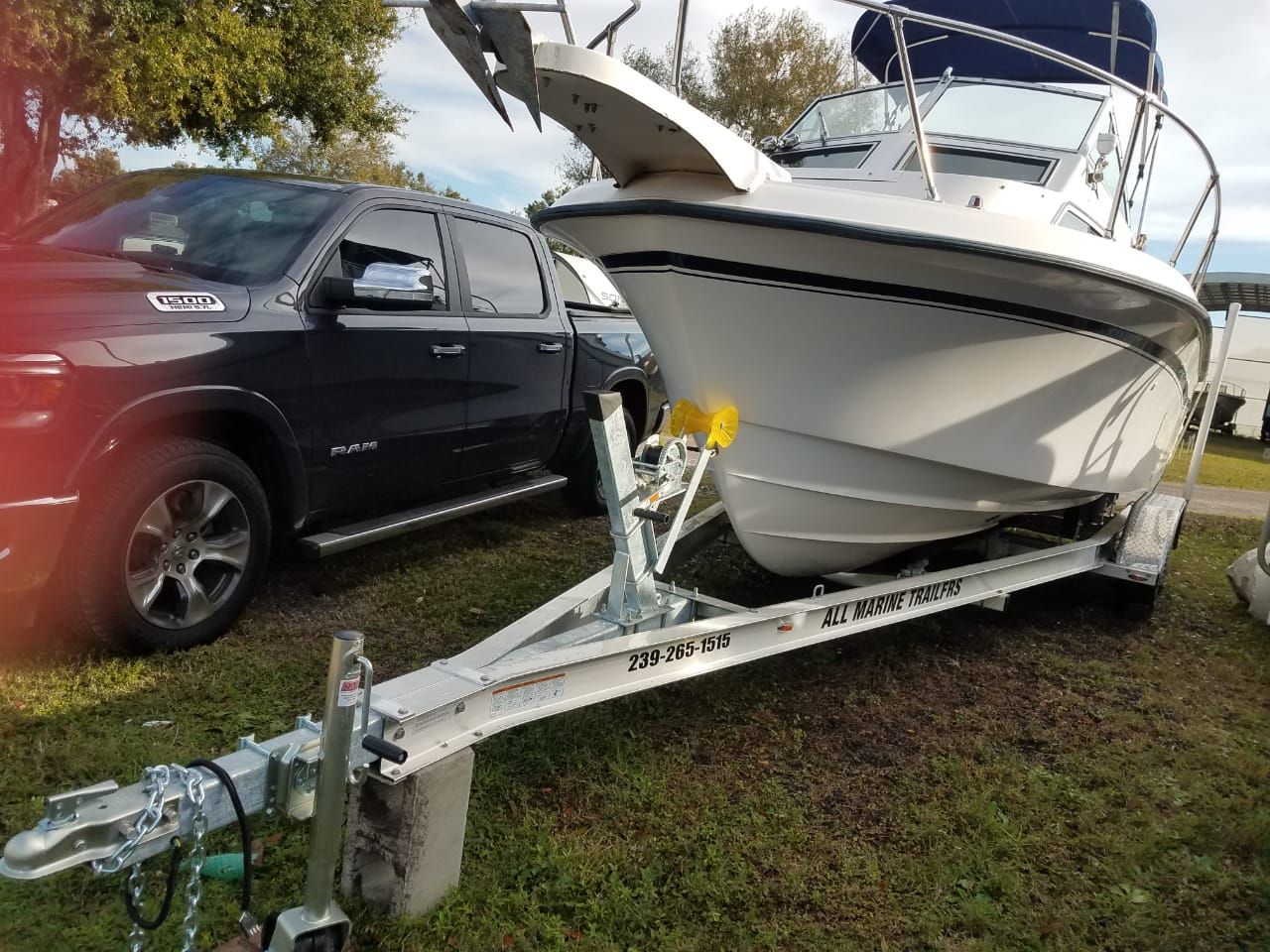 A 1995 Grady-White Explorer 24 on a trailer next to a black pickup truck.