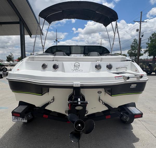 2019 Tahoe 700 boat with canopy, rear view, parked outdoors under cloudy sky.