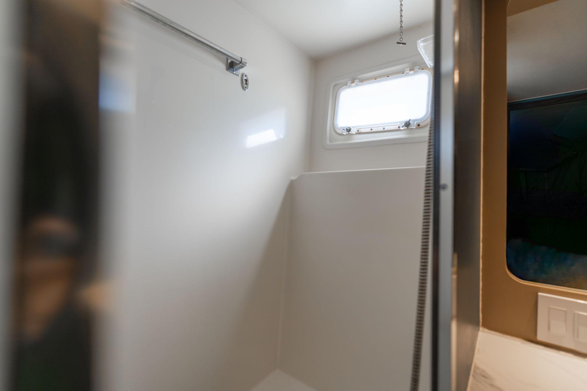 Interior of 1986 Hatteras 63 Motor Yacht bathroom with window and shower area.