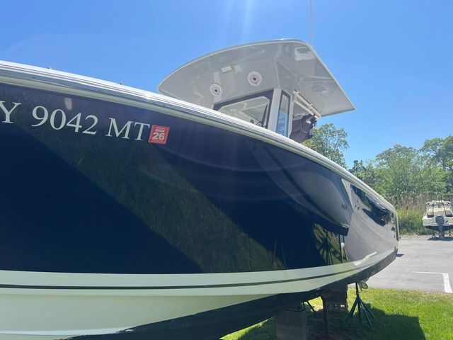 A 2023 Pursuit S268 boat on a trailer under a clear sky.