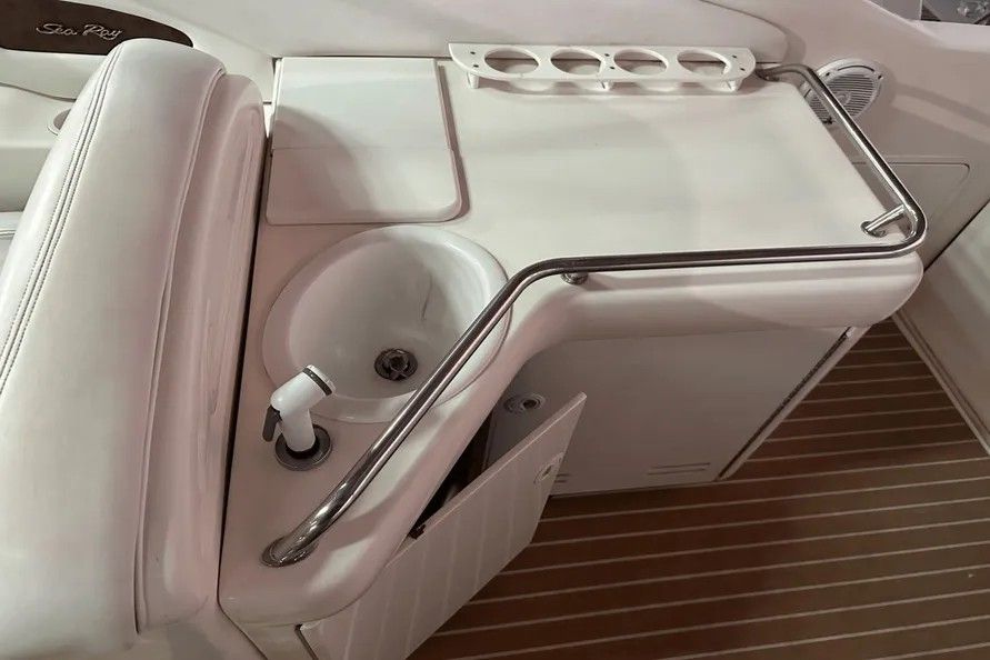 Interior of 1996 Sea Ray Sun Sport with sink and storage.