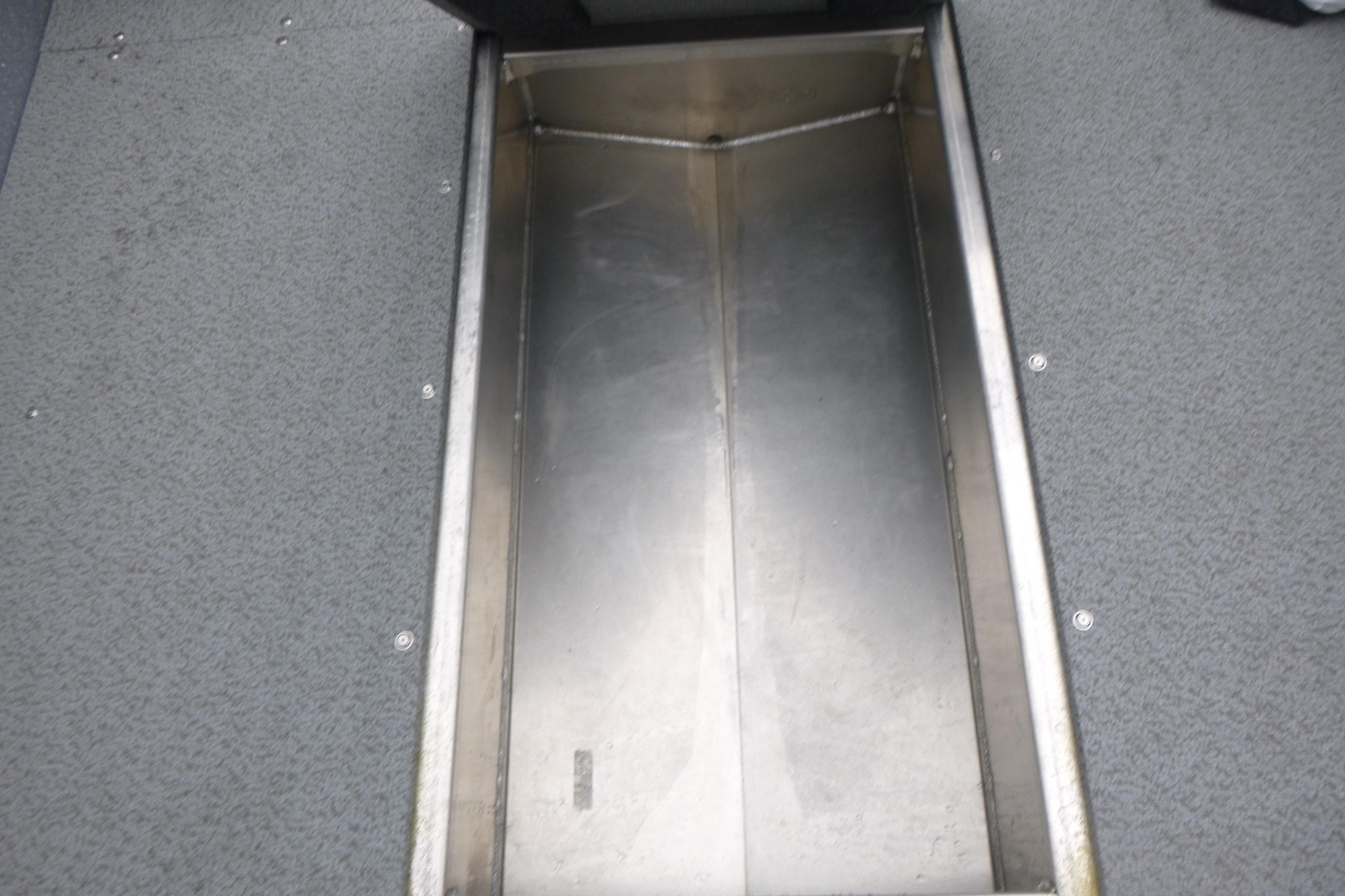 Storage compartment in 2026 KingFisher 2025 Escape boat, featuring metal interior and carpeted edges.