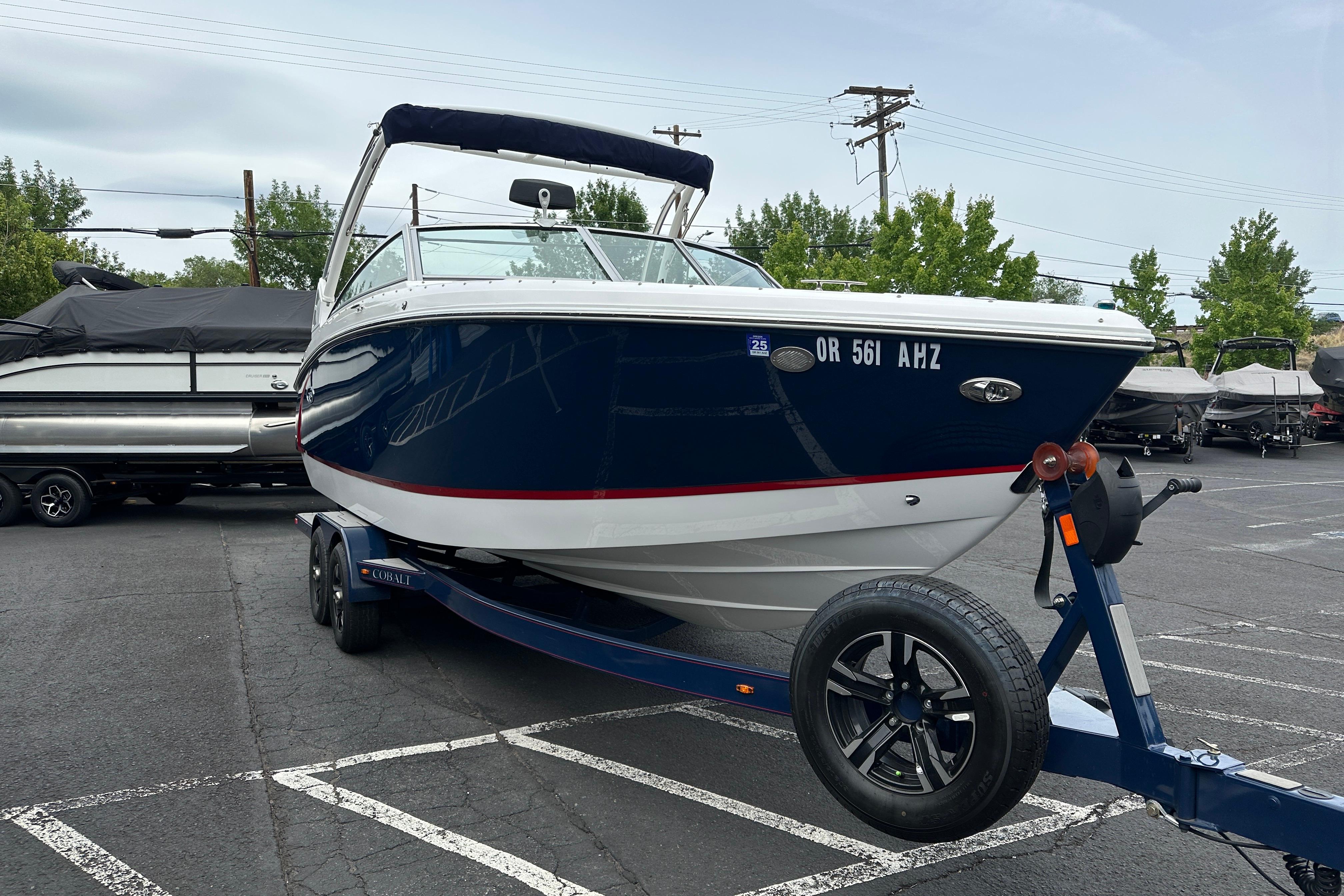 2019 Cobalt R5 boat on trailer in parking lot, surrounded by other boats.