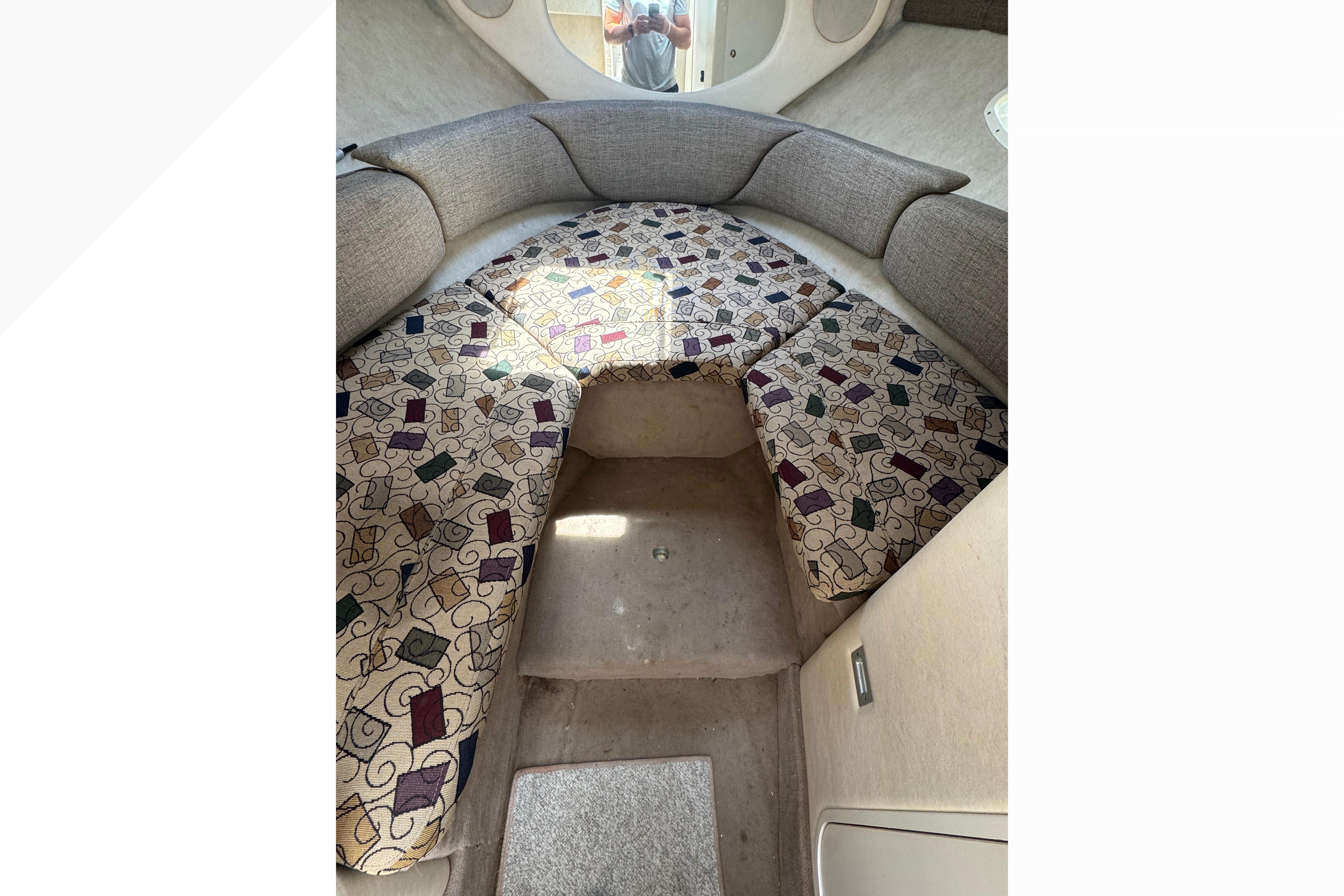 2001 Sea Ray 245 Weekender cabin interior with patterned cushions and cozy seating area.
