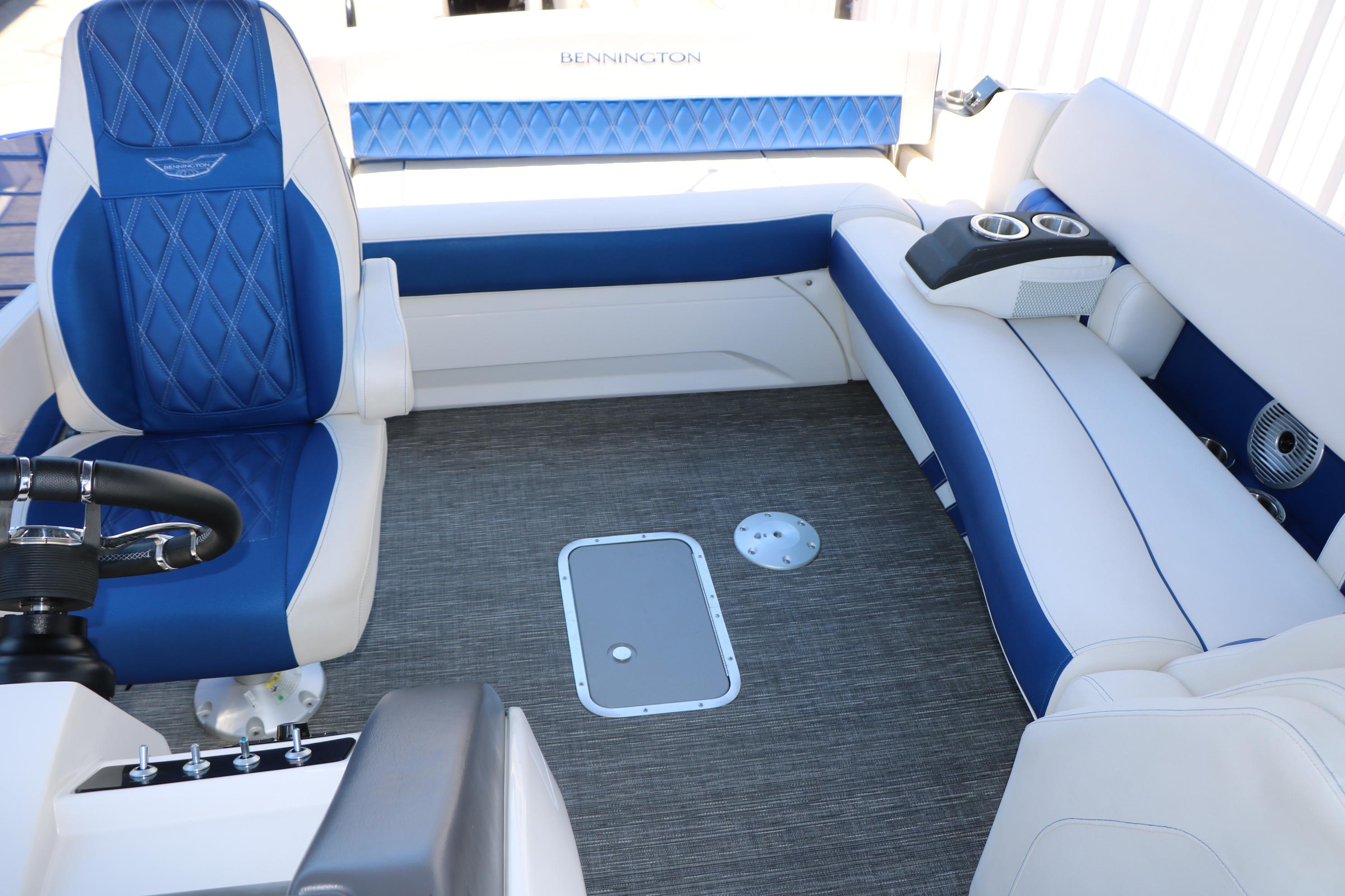 2024 Bennington 23 RX Swingback boat interior with blue and white seating and steering wheel.