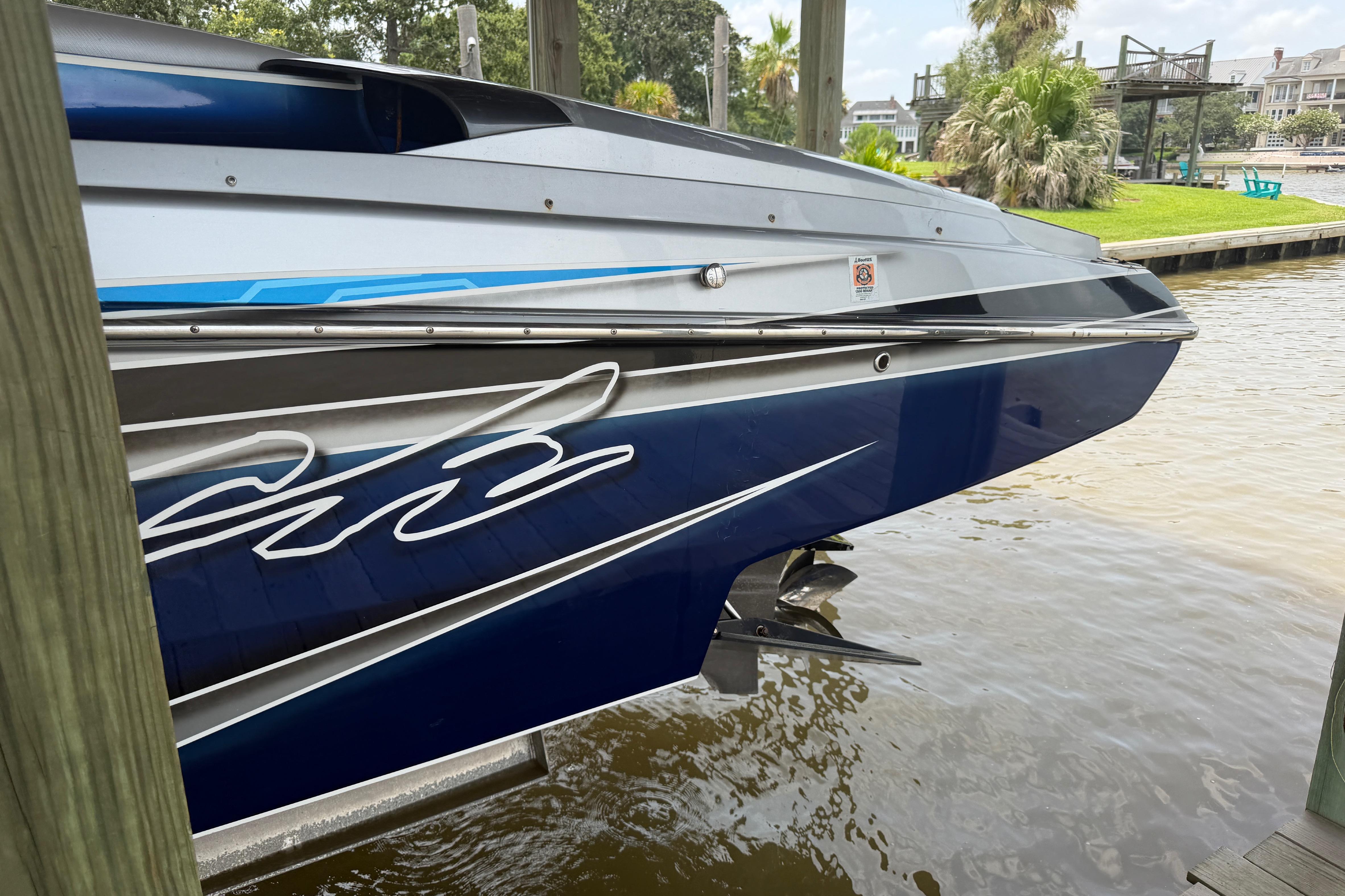 2013 Nor-Tech 477 SPX Vee Bottom boat docked, showcasing sleek blue and silver design.