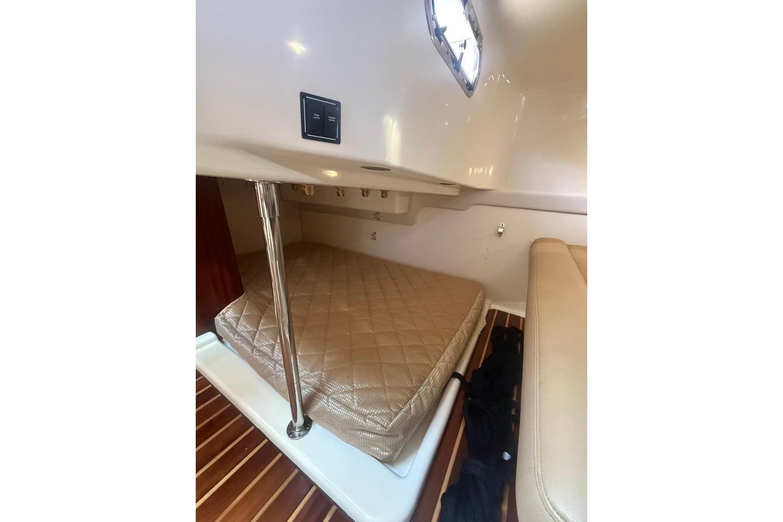 Interior cabin of 2010 Pursuit OS 375 Offshore boat with cushioned seating and wood flooring.