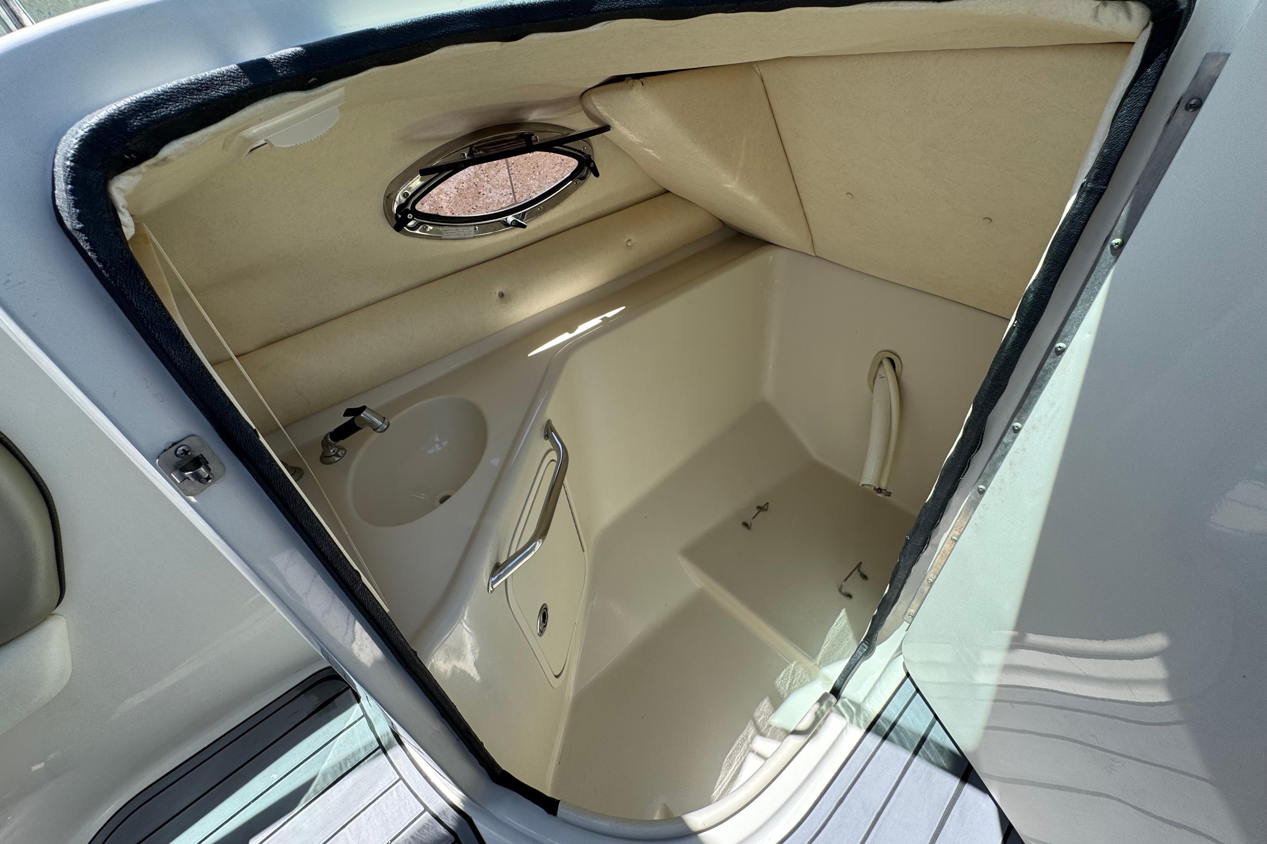 Interior of 2007 Sea Ray 240 Sundeck boat cabin with sink and porthole.