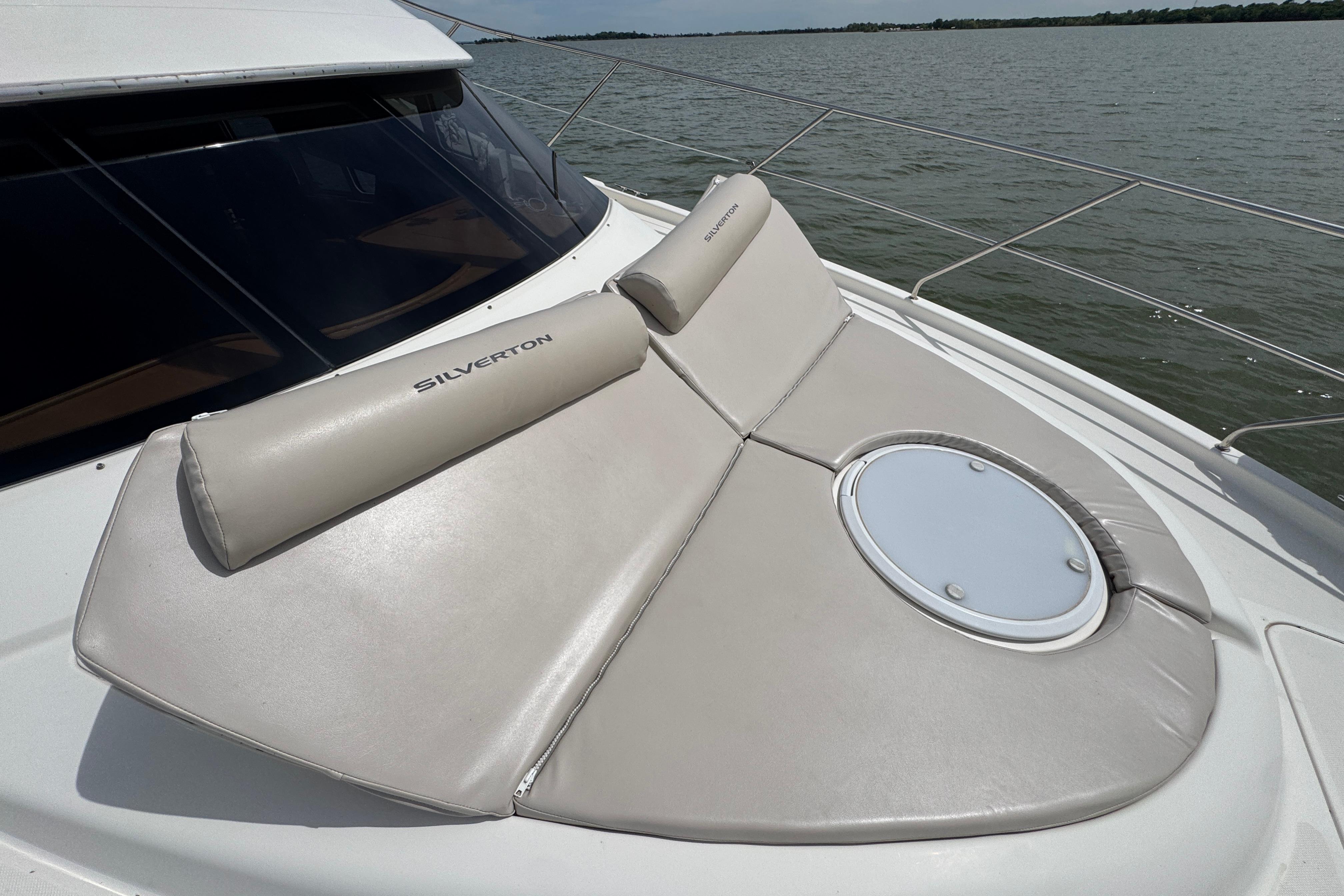 2003 Silverton 39 Motor Yacht with cushioned sunbathing area on deck.