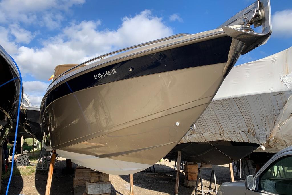 1999 Formula 382 FASTech boat on stands, under a clear blue sky.