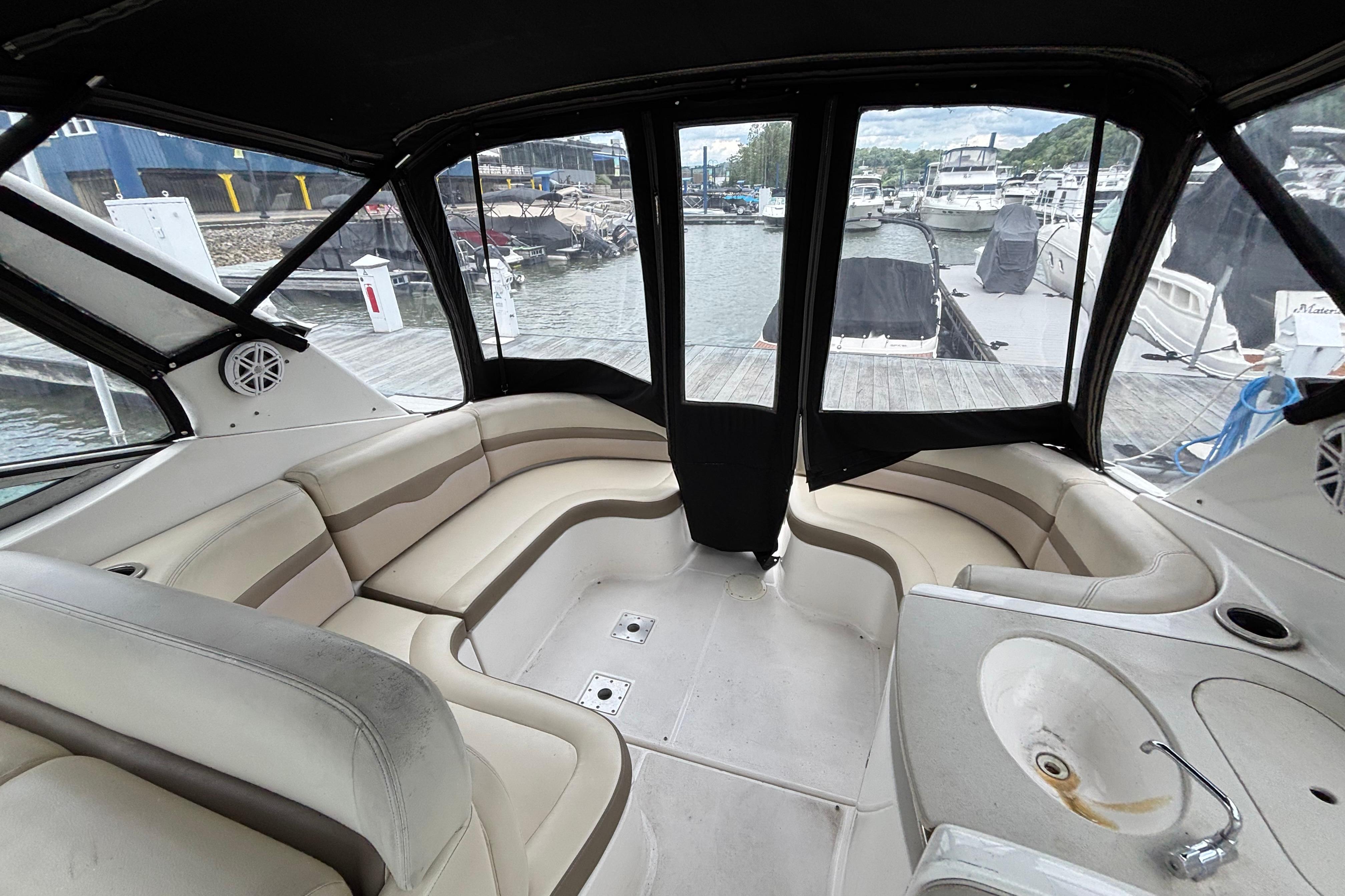 2004 Chaparral Signature 330 boat interior with beige seating and dock view.
