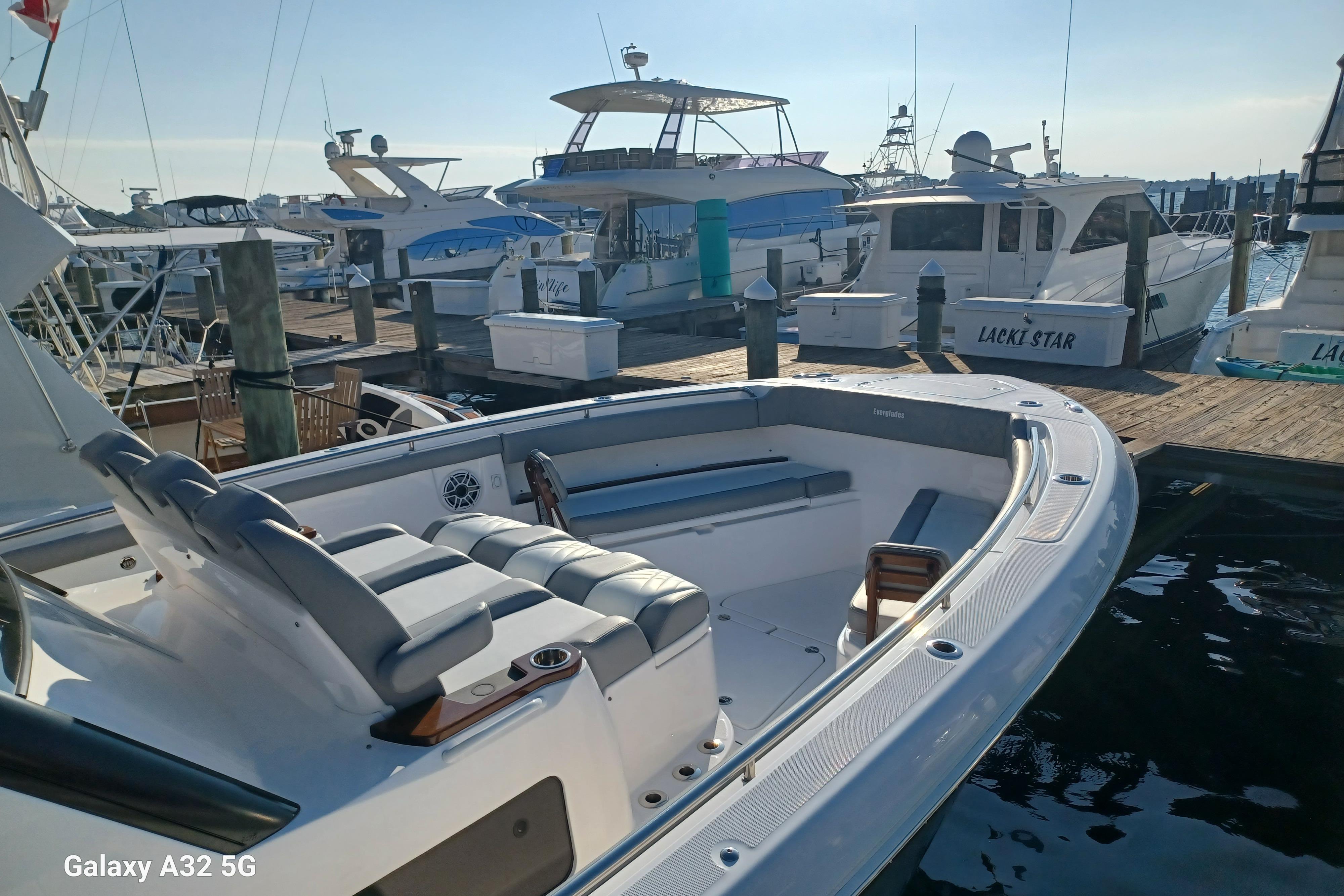 2024 Everglades 455 Center Console boat docked at marina, showcasing sleek design.