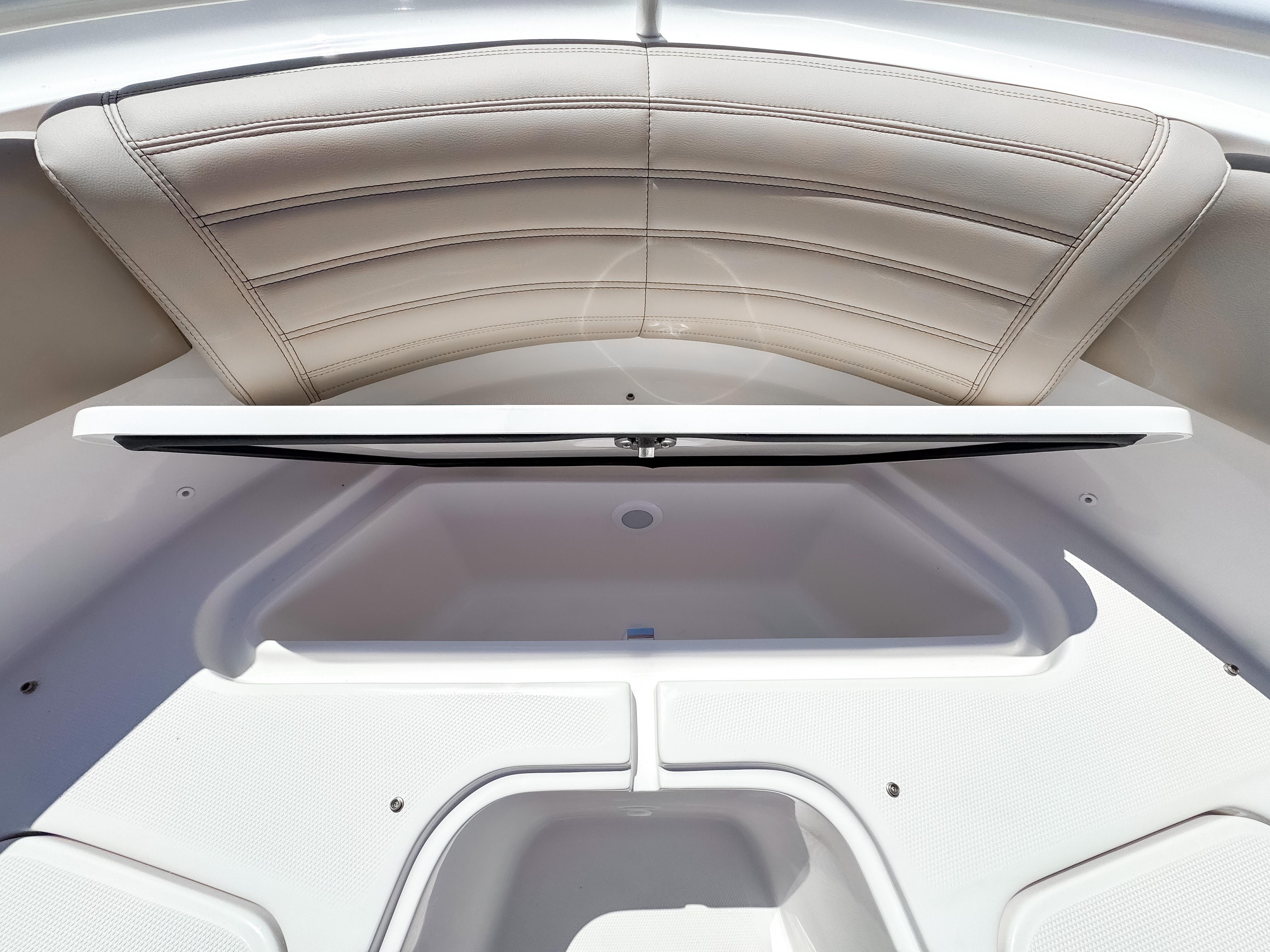 2025 Edgewater 325CC boat interior with open storage compartment and cushioned seating.
