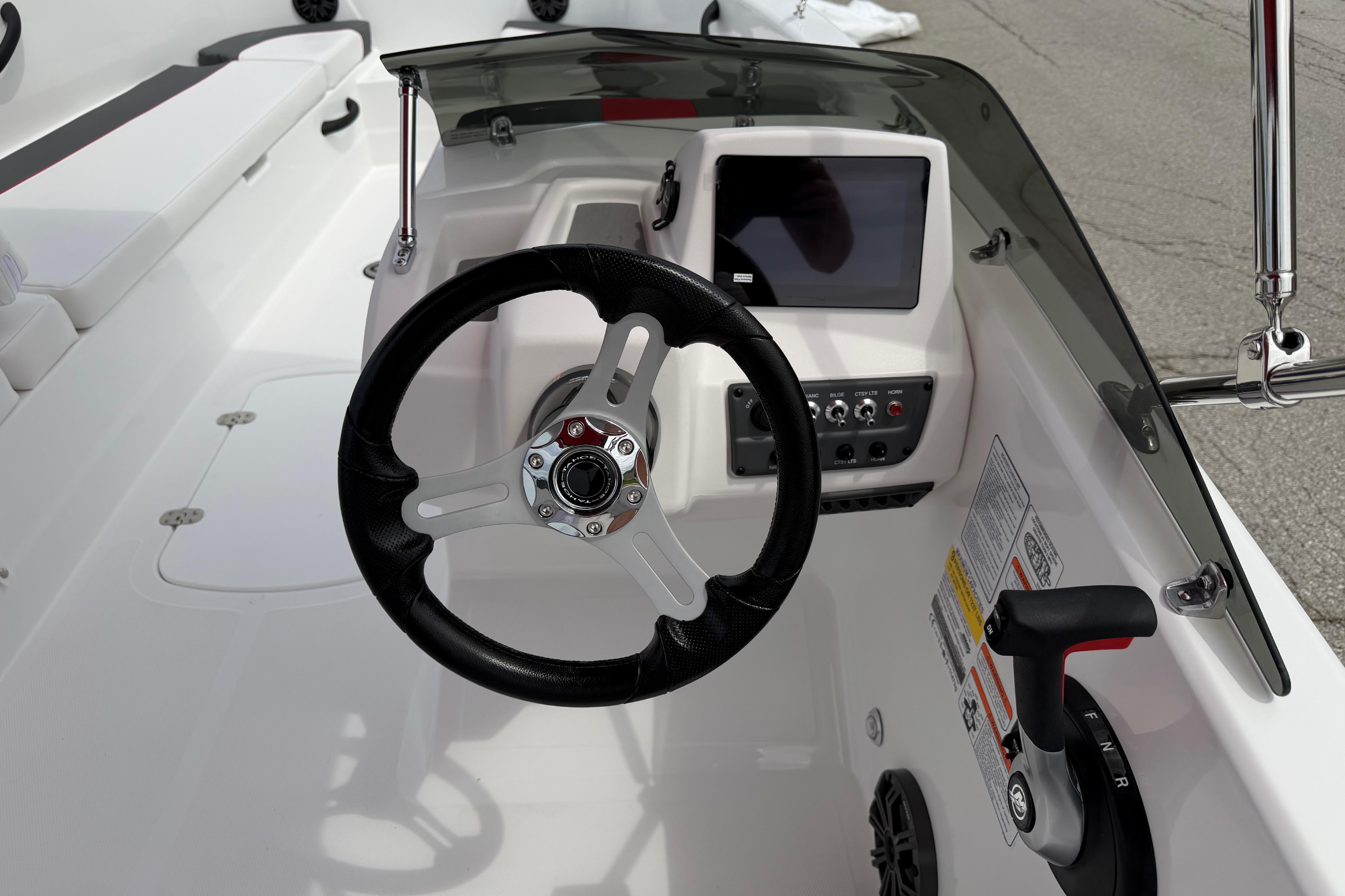 2026 Tahoe T18 boat cockpit with steering wheel, control panel, and seating.