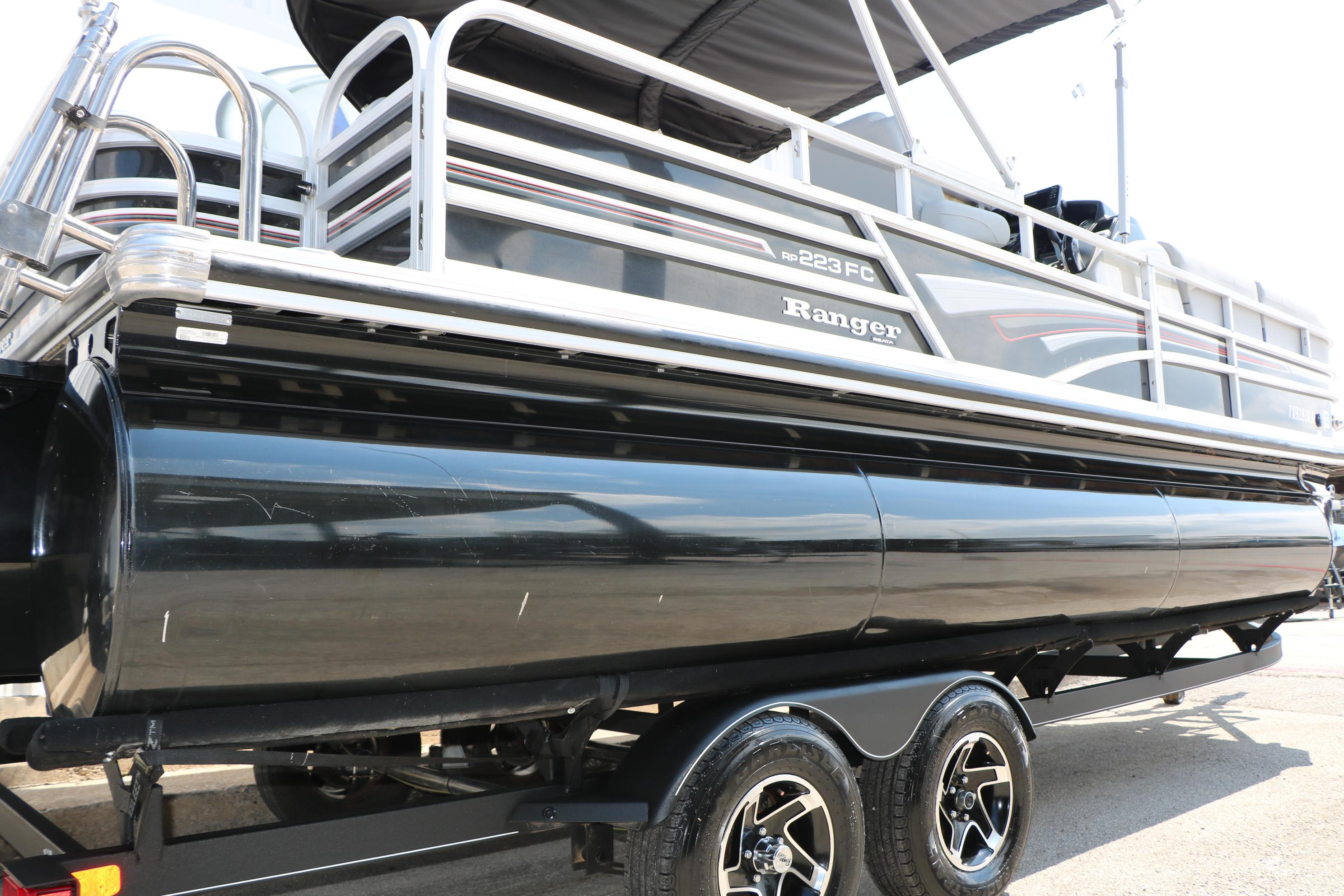 2021 Ranger 223FC pontoon boat on trailer, featuring sleek black and silver design.