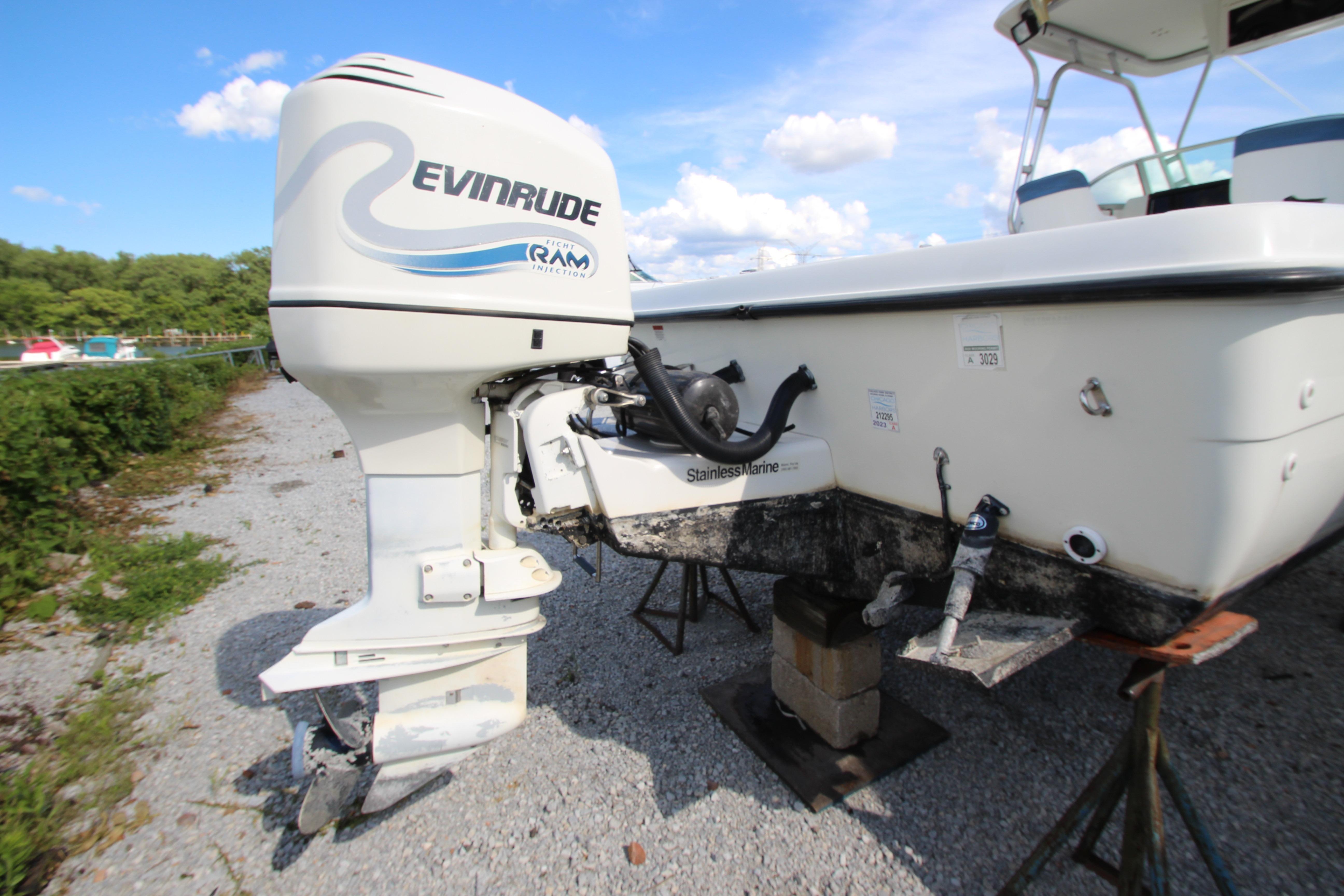 2002 Hydra-Sports 230 WA boat with Evinrude outboard motor on gravel surface.