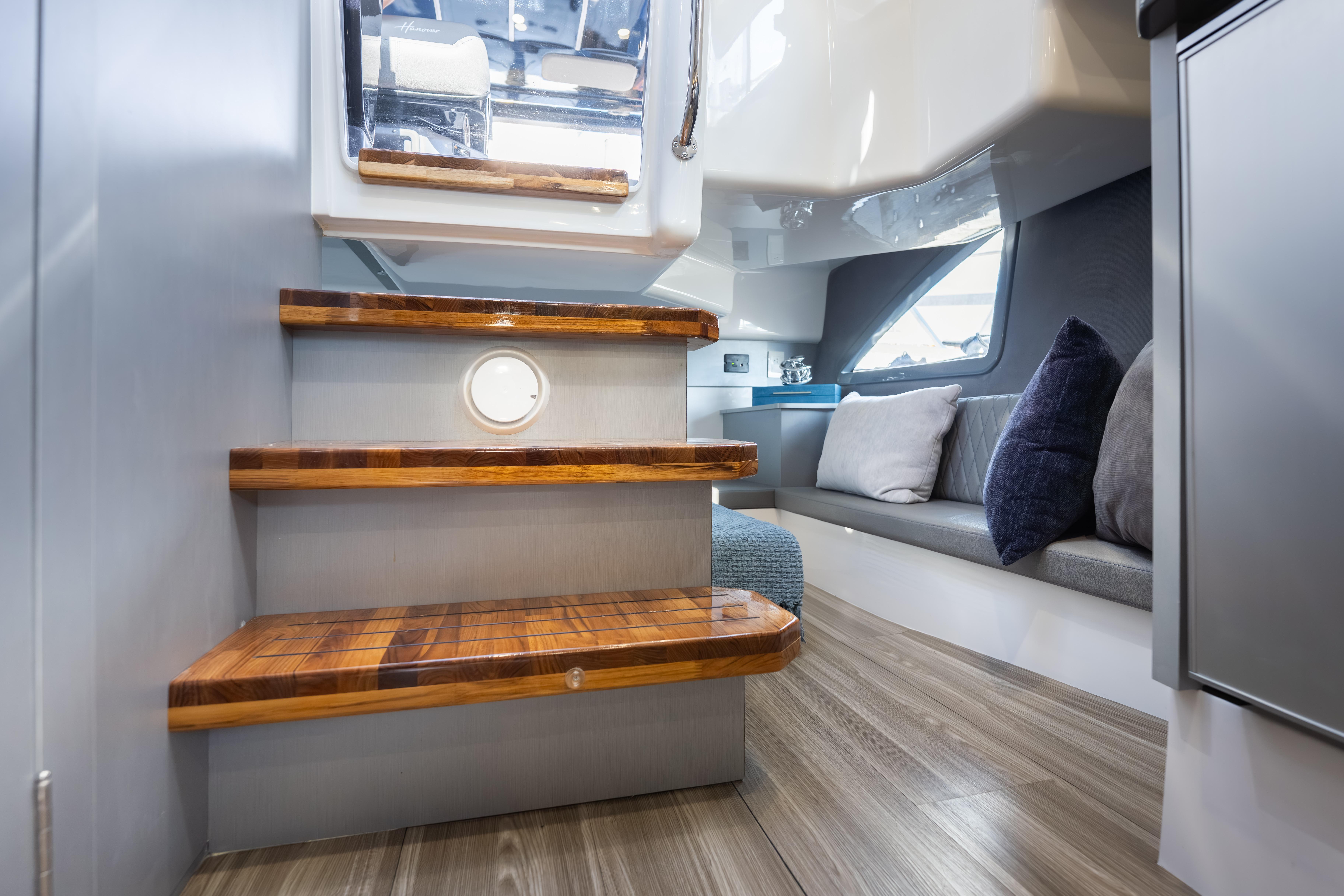 Interior of 2026 Hanover 347 yacht with wooden steps and cozy seating area.