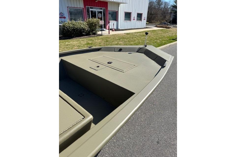 2026 Tracker Grizzly 1648 SC boat parked outside a building on a sunny day.
