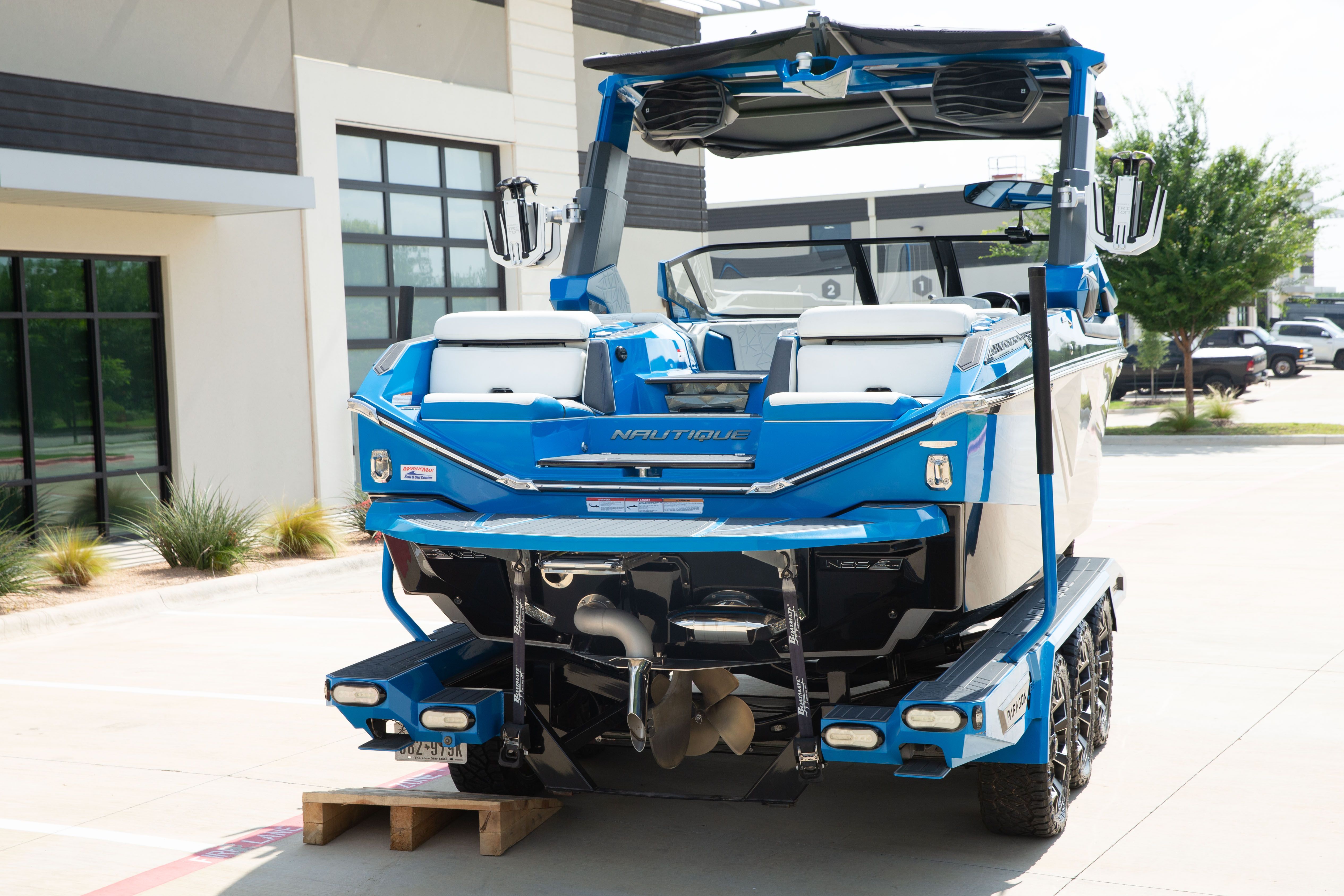A blue Nautique Super Air Nautique G23 Paragon boat on a trailer.