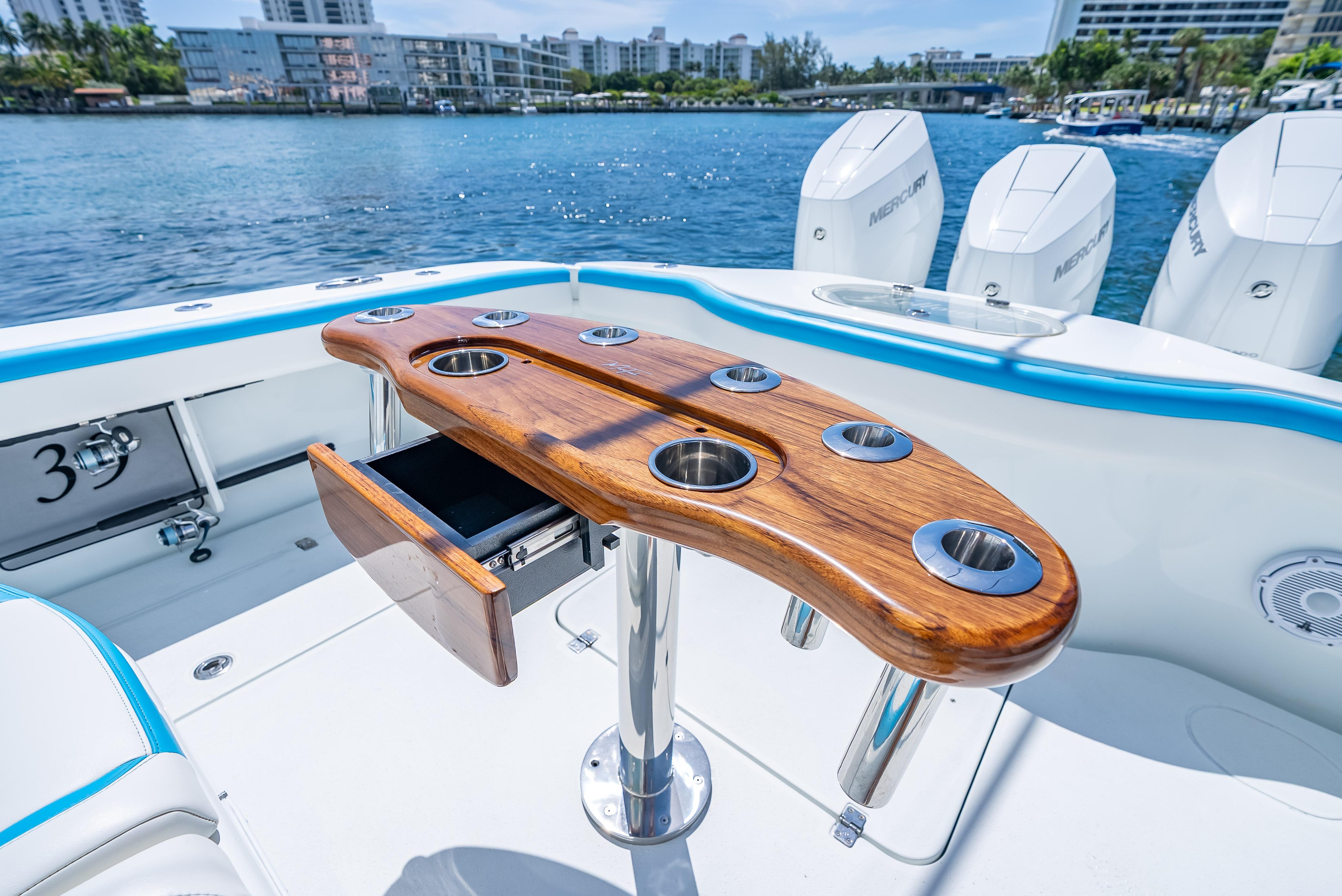 2016 Yellowfin 39 Offshore boat with wooden rod holder, Mercury engines, and scenic waterfront view.