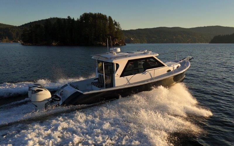 2024 True North 34 boat cruising on a scenic lake at sunset.
