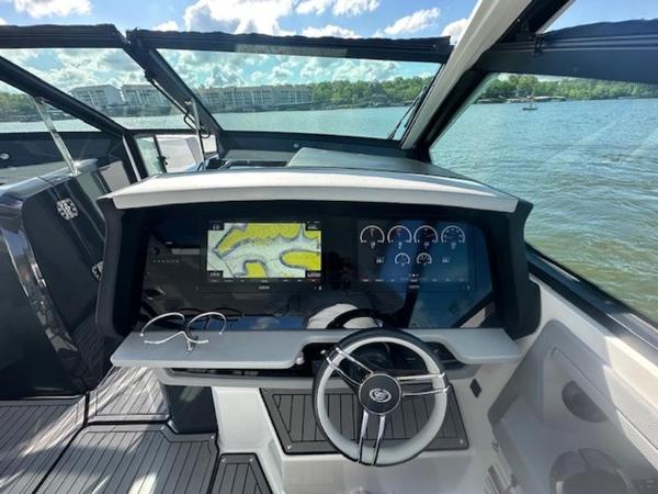 2022 Cobalt A36BR boat dashboard with navigation screens and steering wheel on a sunny day.