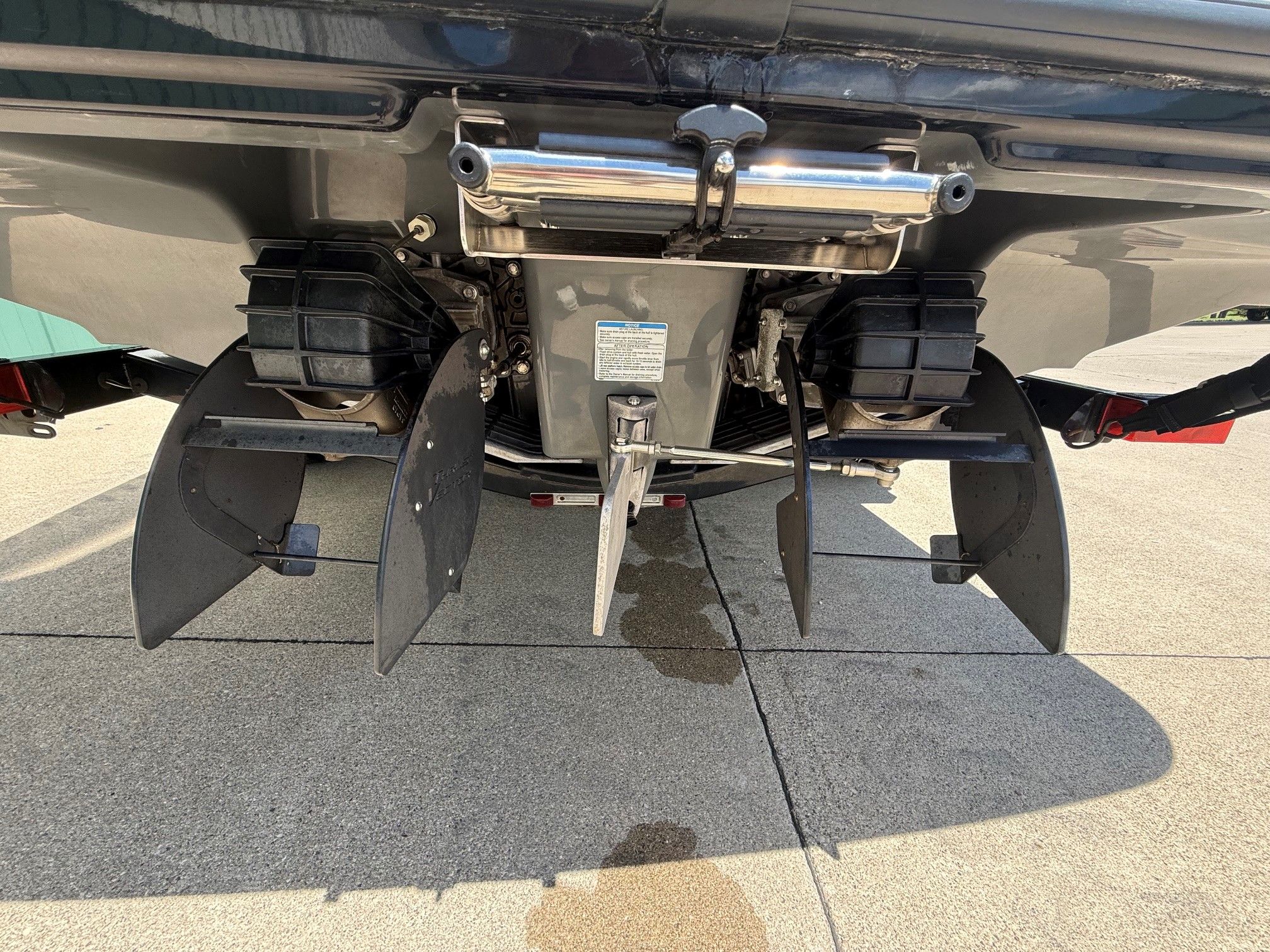 Rear view of a Yamaha SX210 boat with dual jet drives on a concrete surface.