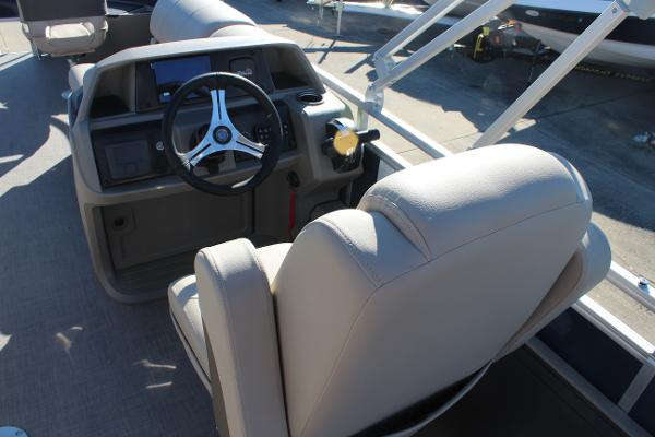 2025 Sun Tracker Fishin' Barge 22 DLX helm with steering wheel and beige seating.