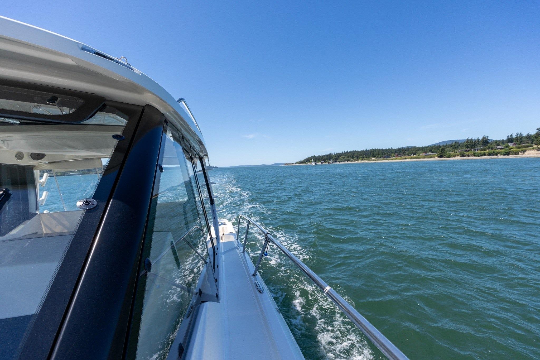 Boston Whaler 405 Conquest cruising on open water, clear blue sky, 2023 model.