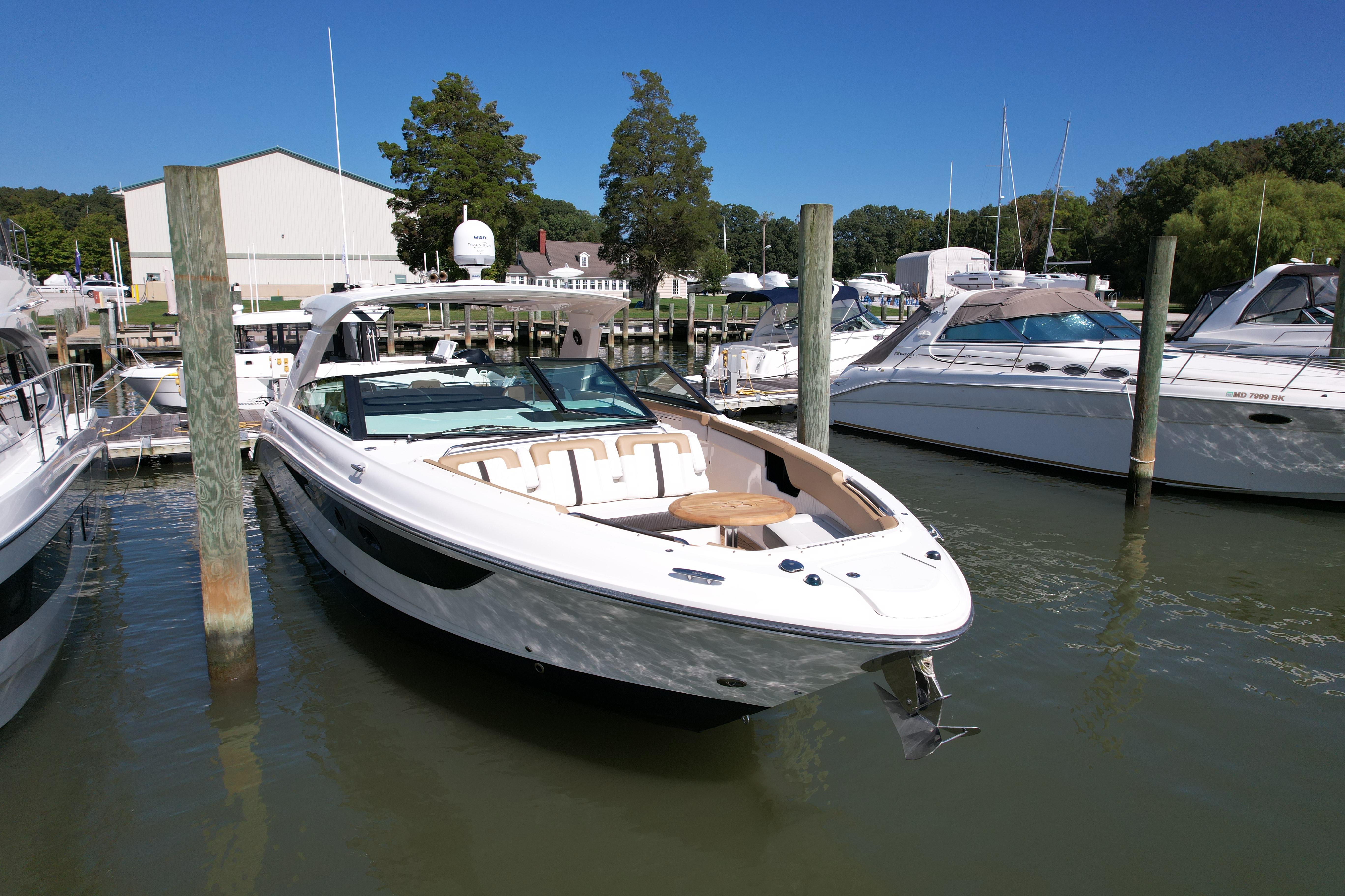 2019 Sea Ray SLX 400 boat docked in a marina under clear blue skies.
