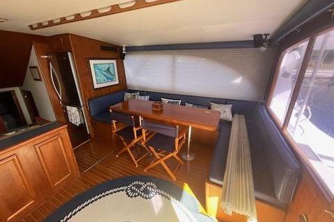 Interior of 1987 Topaz 44 Flybridge yacht with dining area and wooden furnishings.