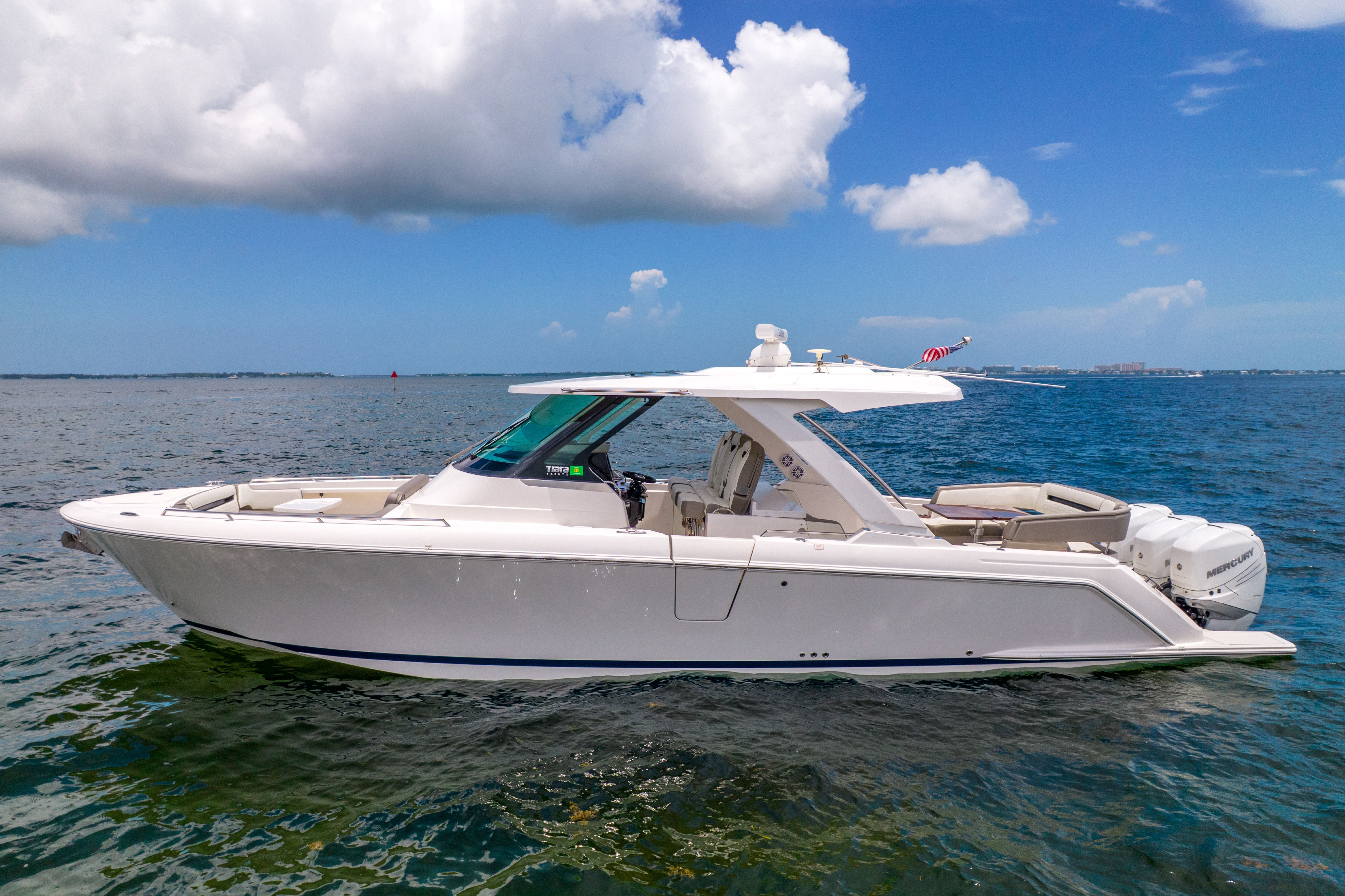 A sleek, modern boat on calm water with a clear sky in the background.