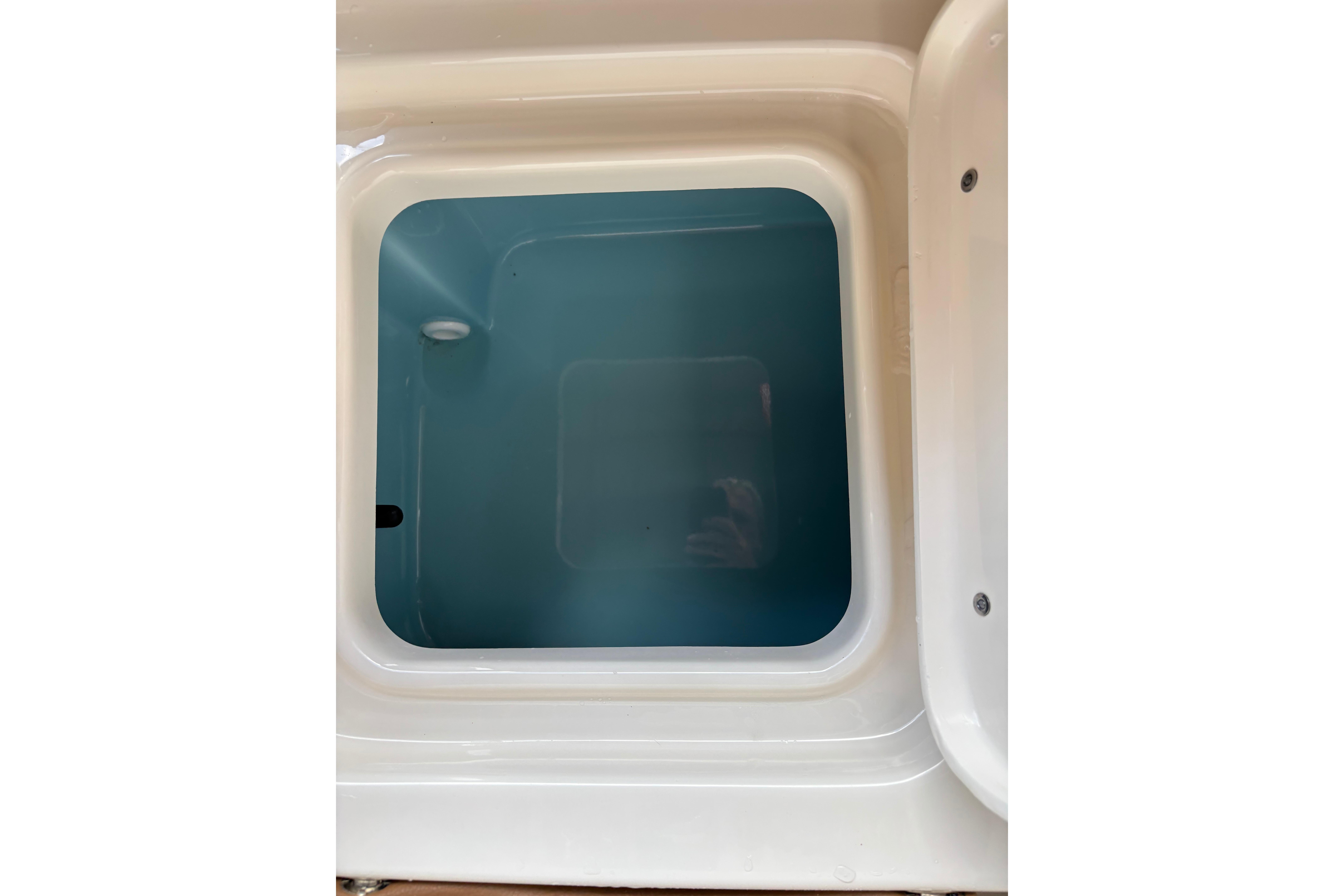 Livewell compartment of 2024 Pioneer 180 Islander boat, featuring a clean, white interior.