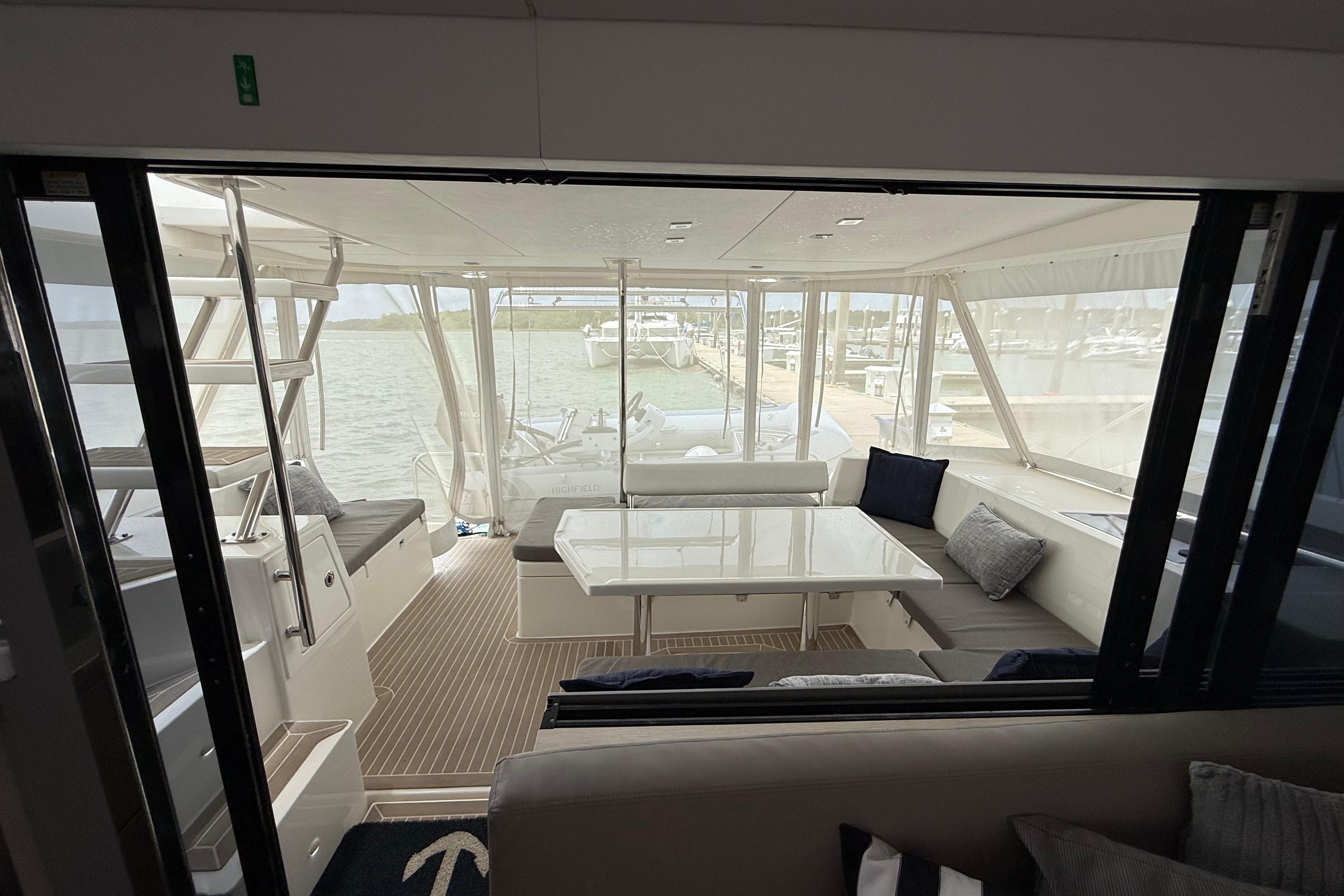 Interior view of 2021 Leopard 43 Powercat with spacious seating and waterfront backdrop.