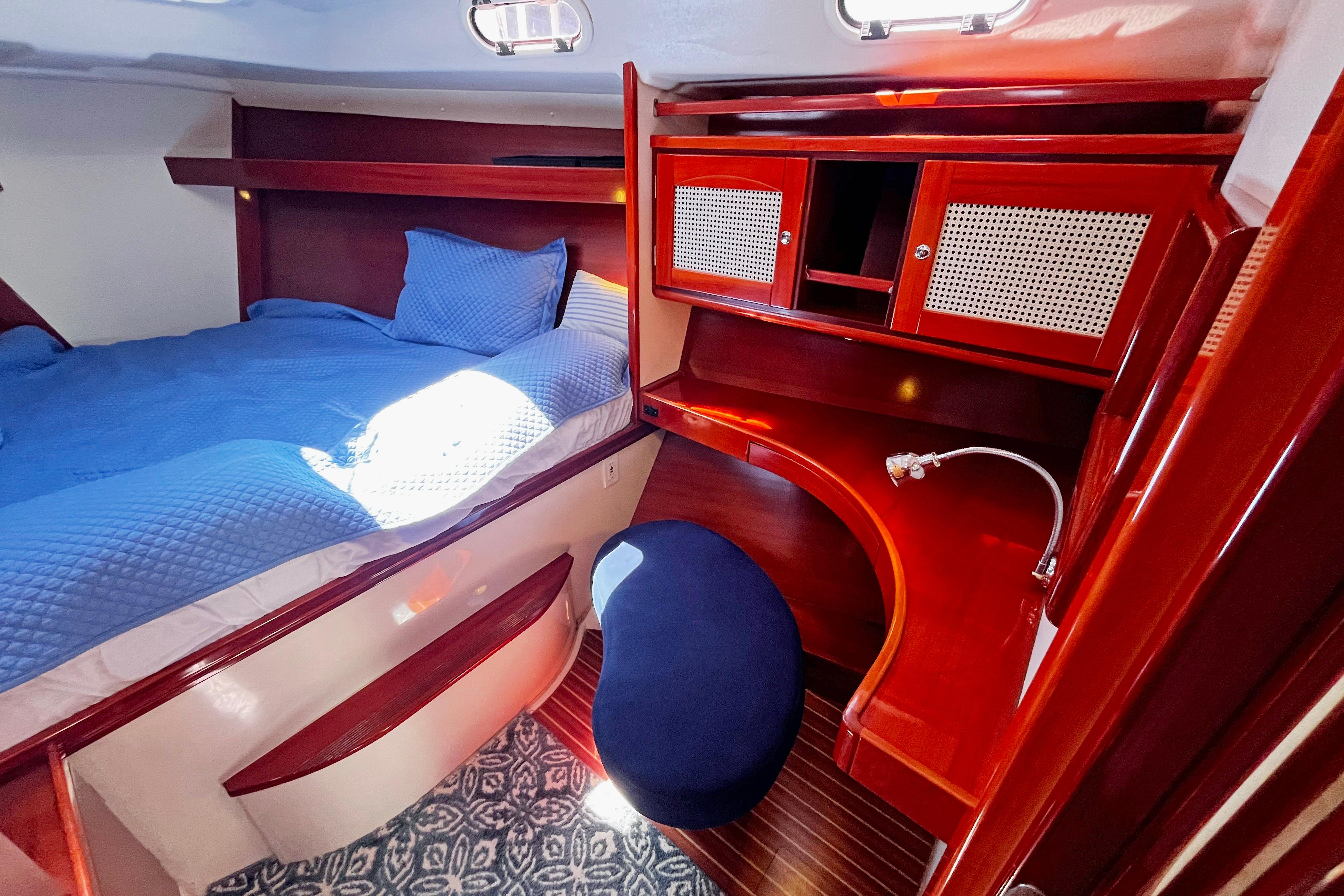 Luxurious cabin interior of a 2004 Hanse 411 yacht with wooden furnishings and blue bedding.