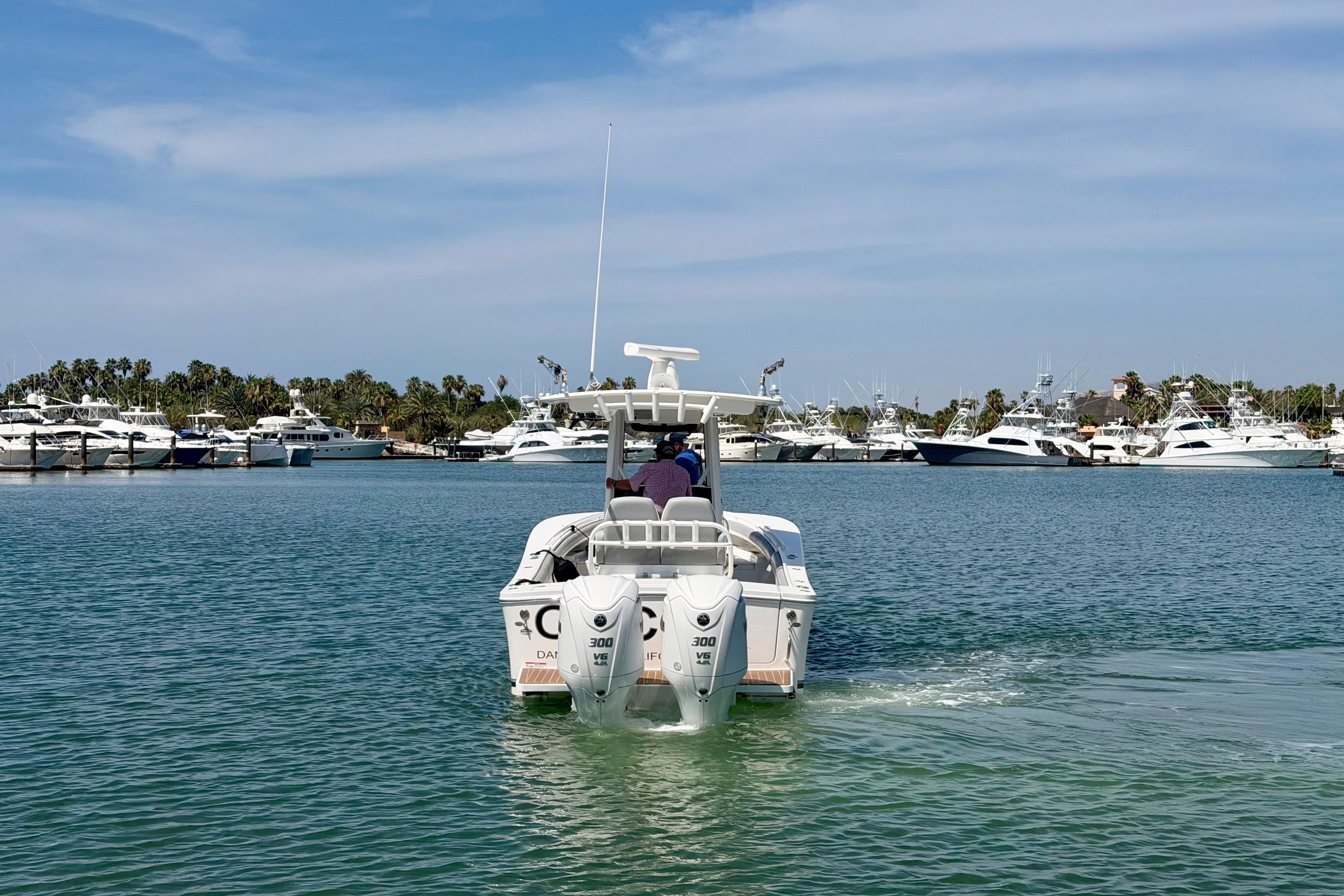 2022 Regulator 28 boat cruising in a marina with yachts and palm trees.