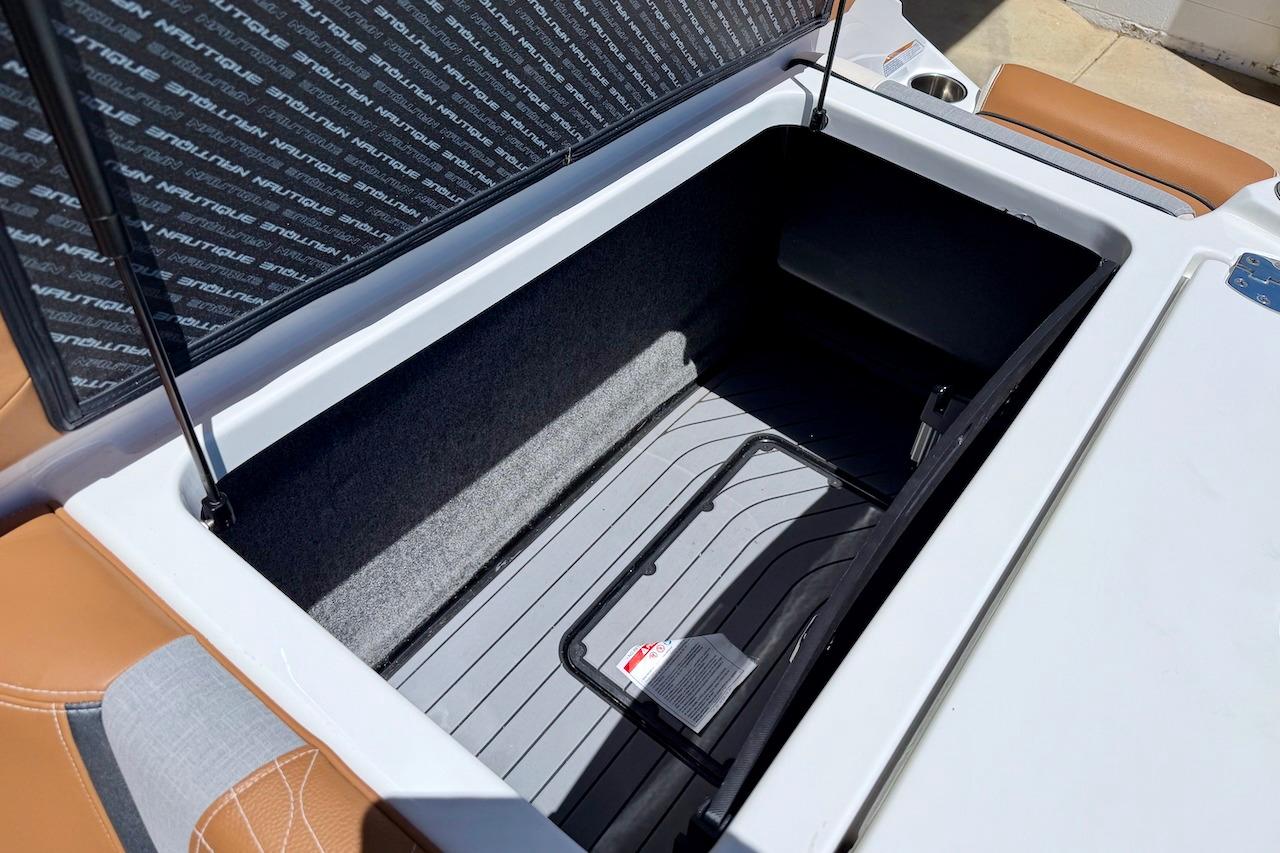 Open storage compartment in 2021 Nautique Super Air Nautique G23 boat, featuring cushioned seating.