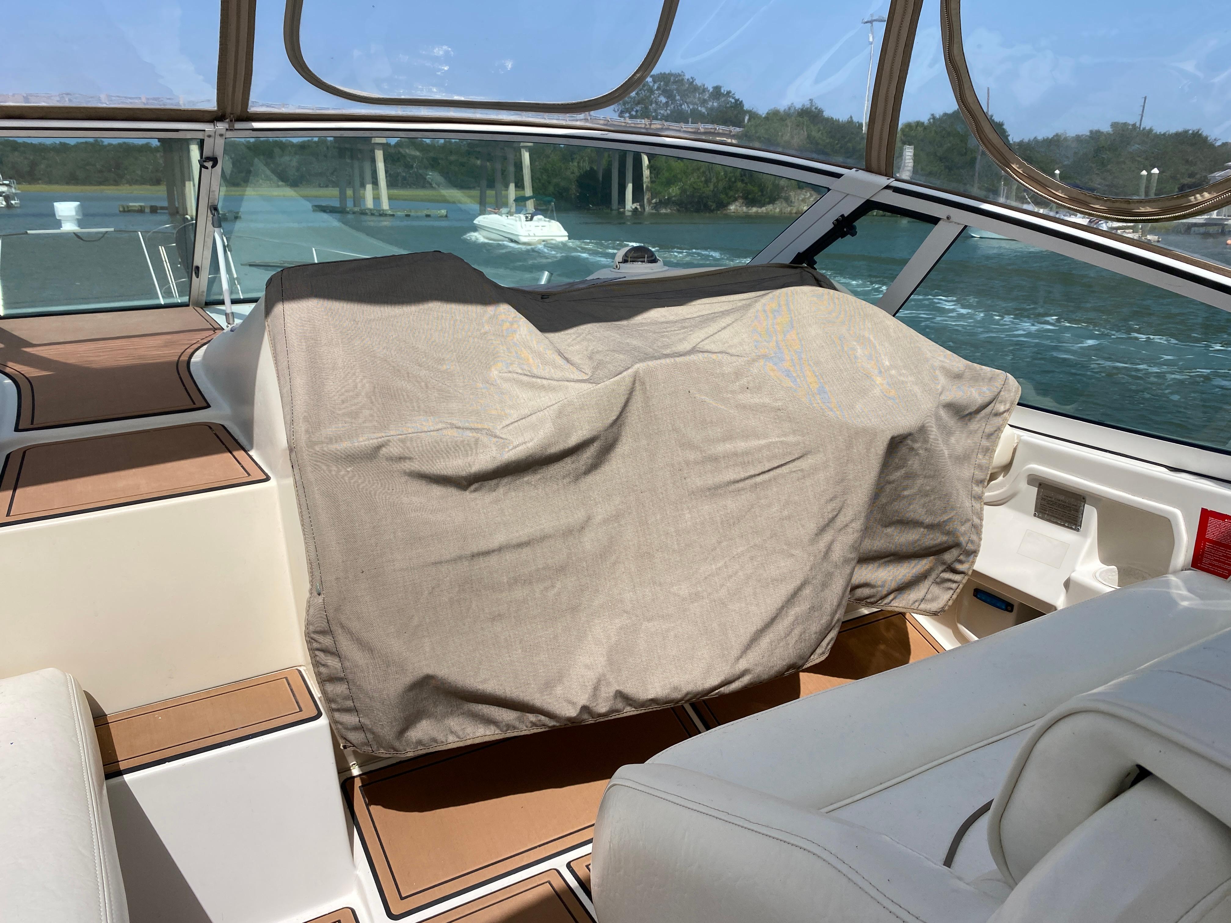 Cruisers 3672 yacht interior, 2000 model, with covered dashboard and scenic water view.