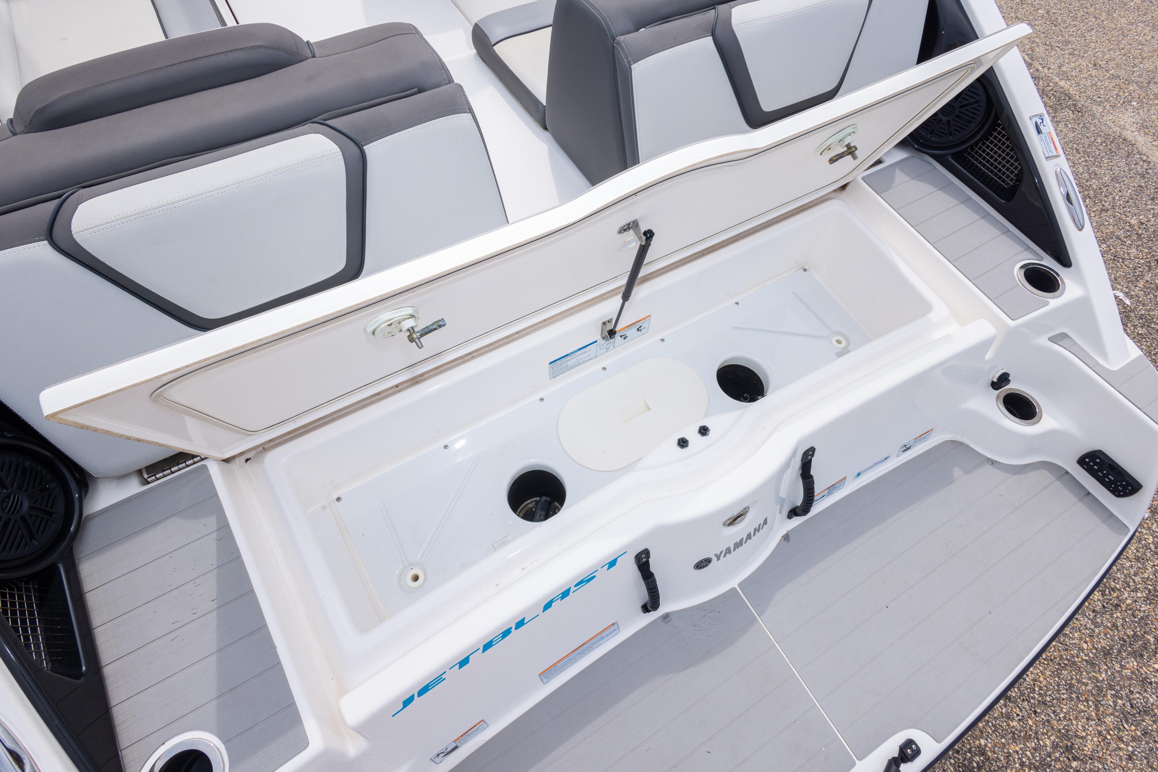2021 Yamaha Boats AR250 storage compartment with open lid, showcasing spacious interior design.